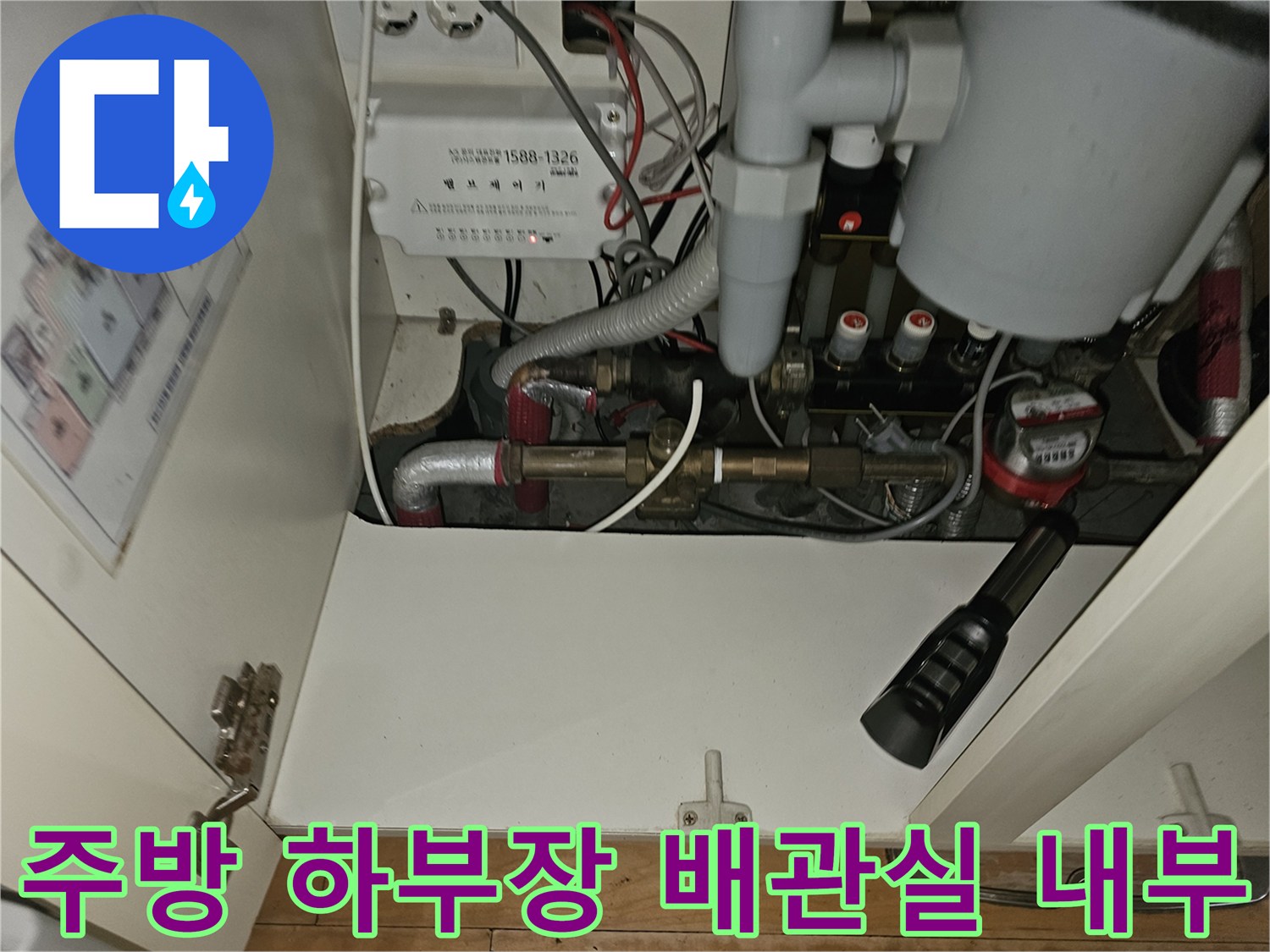 분당 백현동 아파트 주방 싱크대 아래 난방 분배기와 연결된 금속 배관 모습