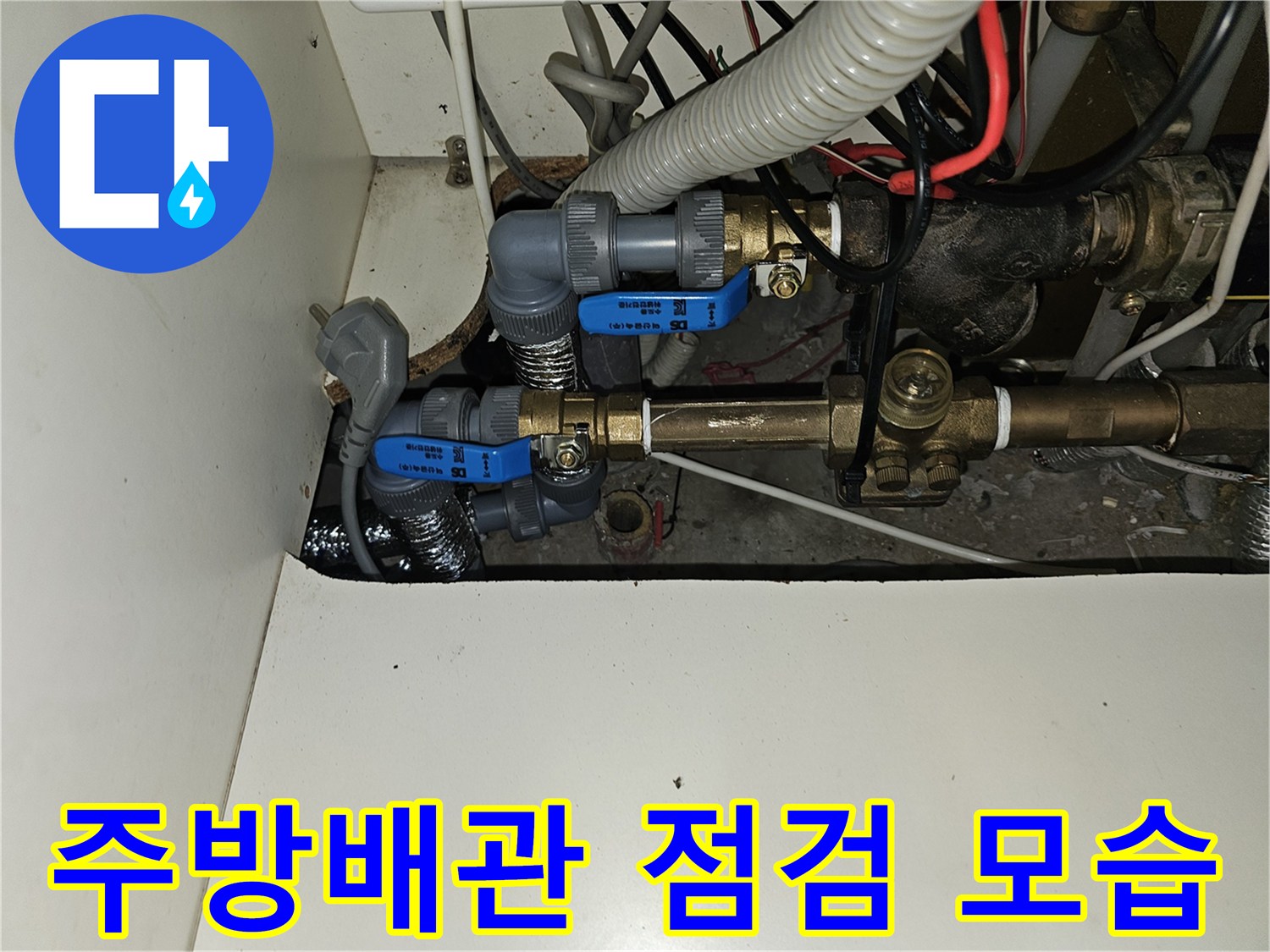 분당 백현동 아파트 주방 하부장 내부의 난방 분배기 및 배관 연결 부위 사진입니다.