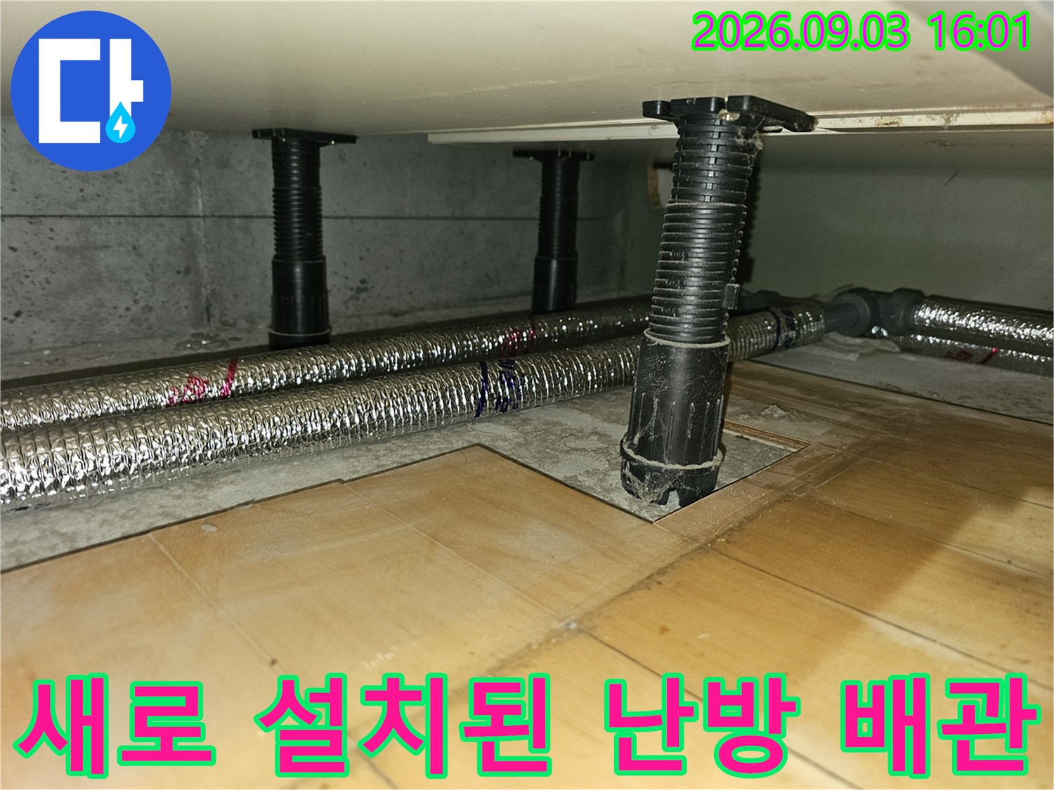은색 보온재로 마감된 신설 난방 배선과 검정색 고정용 지지대 구조
