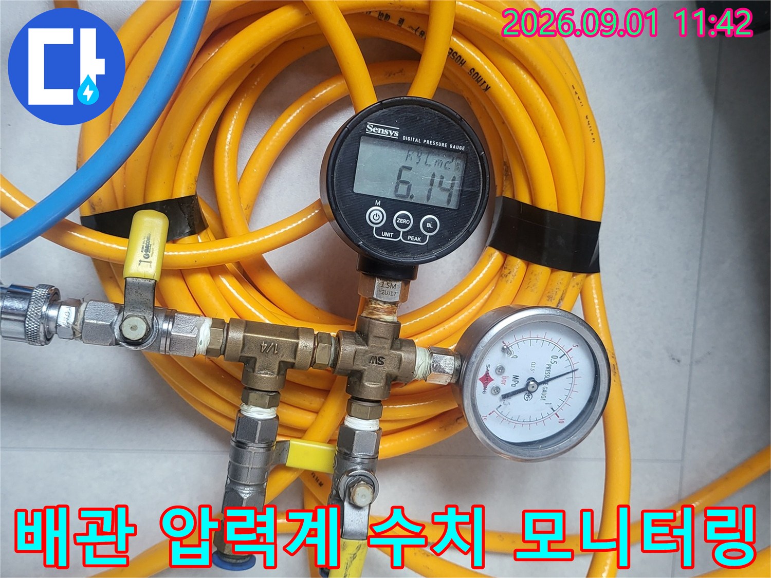노란색 호스와 연결된 아날로그 및 디지털 압력계
