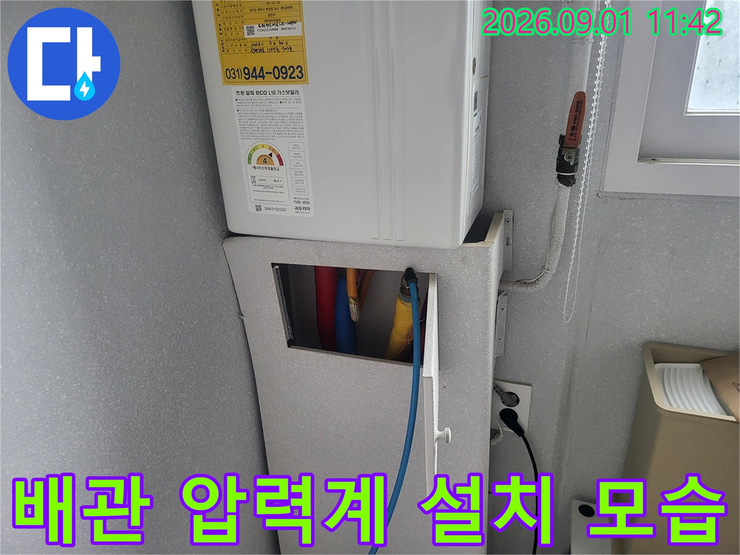 보일러 배관에 연결된 디지털 게이지와 파란색 호스입니다.