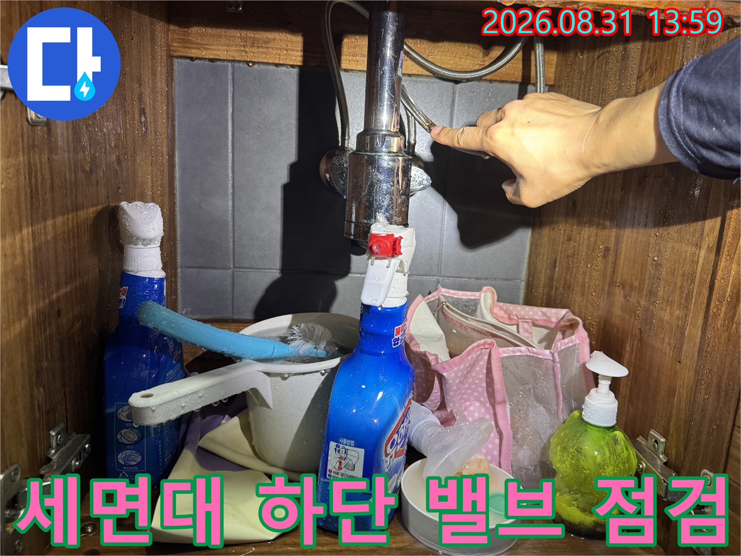 세면대 아래쪽 수도 밸브와 배관 연결 부위를 직접 확인하는 모습입니다.