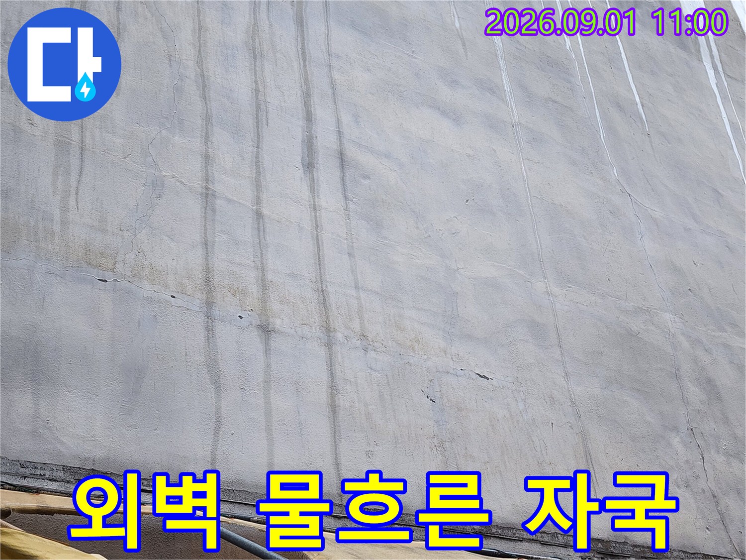 건물 외벽에 세로로 길게 남은 물 흐른 자국과 얼룩 현상