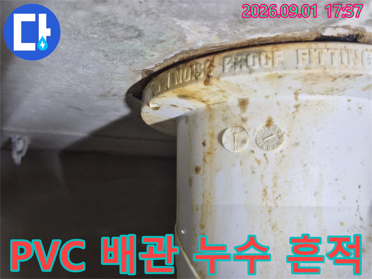 하얀색 PVC-배관 주변에 묻어있는 갈색 누수 얼룩을 클로즈업한 사진입니다.