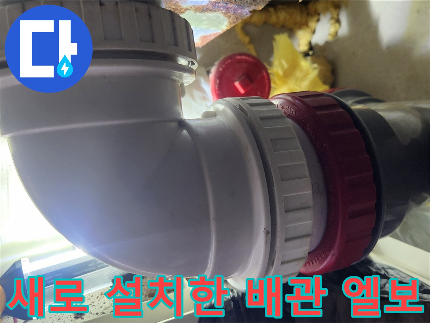 배수관 연결 부위에 - 새로 적용된 - 흰색 PVC 엘보와 붉은색 패킹