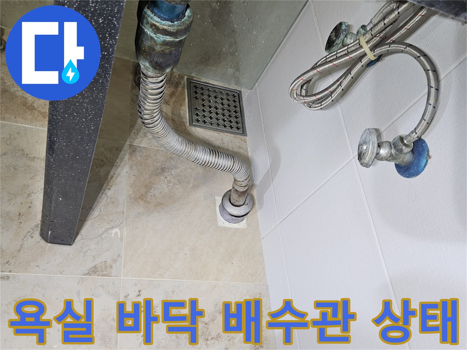 벽면 배관과 바닥 배수구가 연결된 구조물 사진