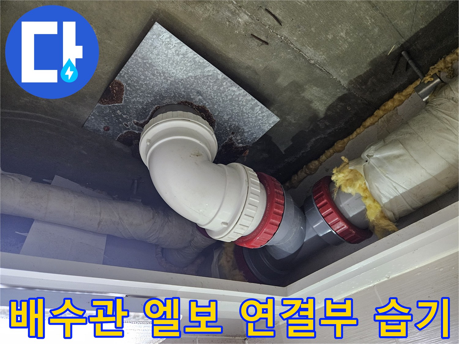 화장실 천장-배수관 연결 부위의 오염과 젖어 있는 보온재 상태를 보여줍니다.
