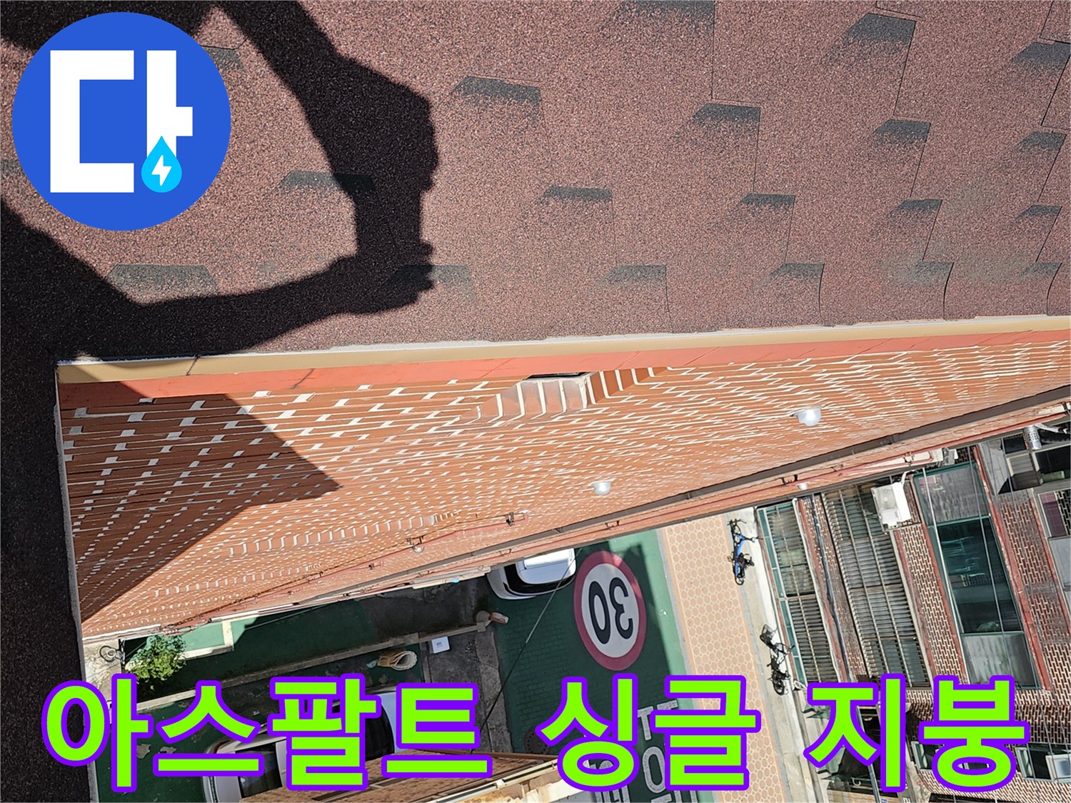 건물 상단의 아스패트 싱글 마감재와 외벽 경계 부분입니다.