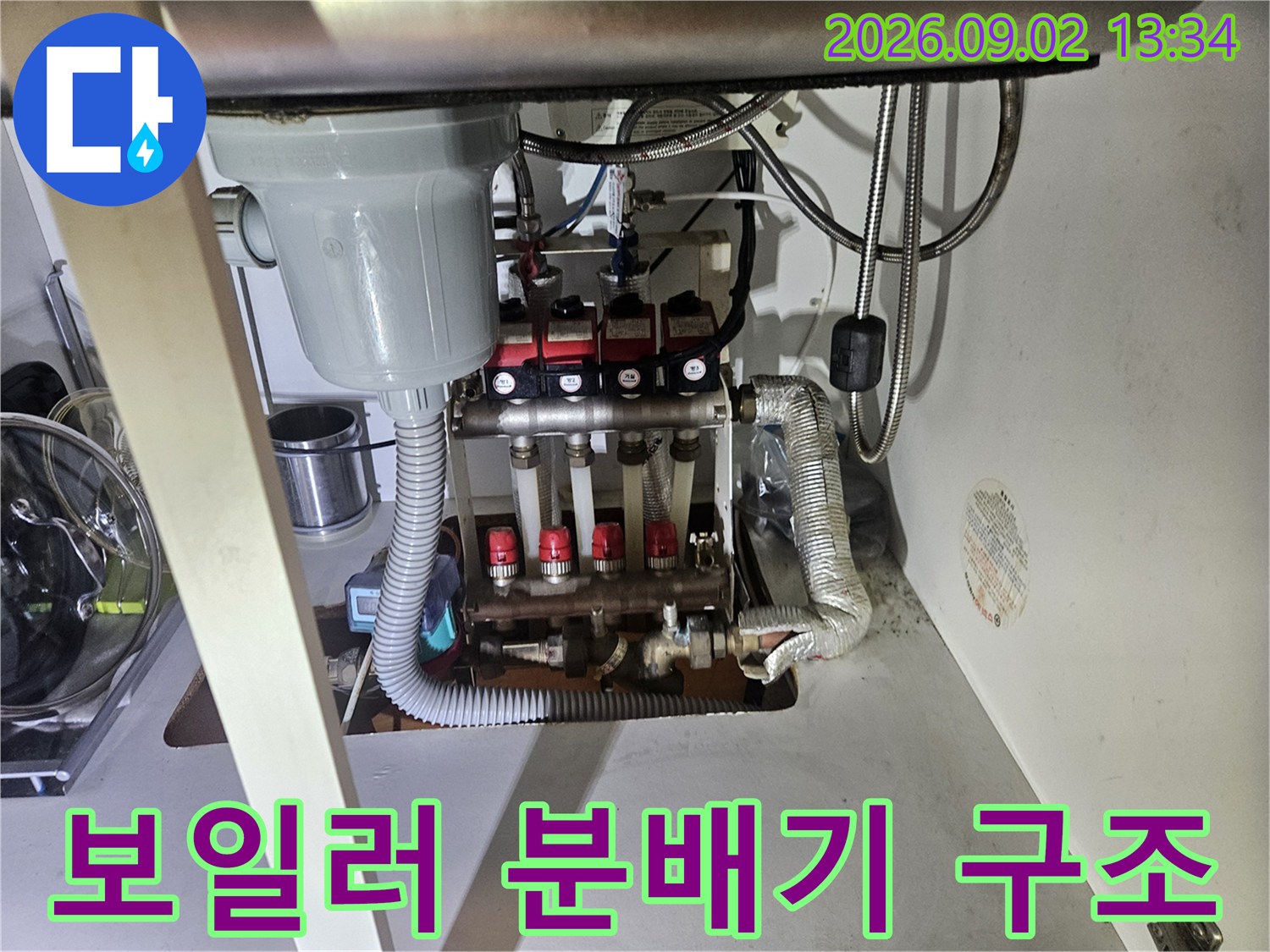 싱크대 하부에 위치한 보일러 분배기와 연결 배관들의 상세 모습입니다.