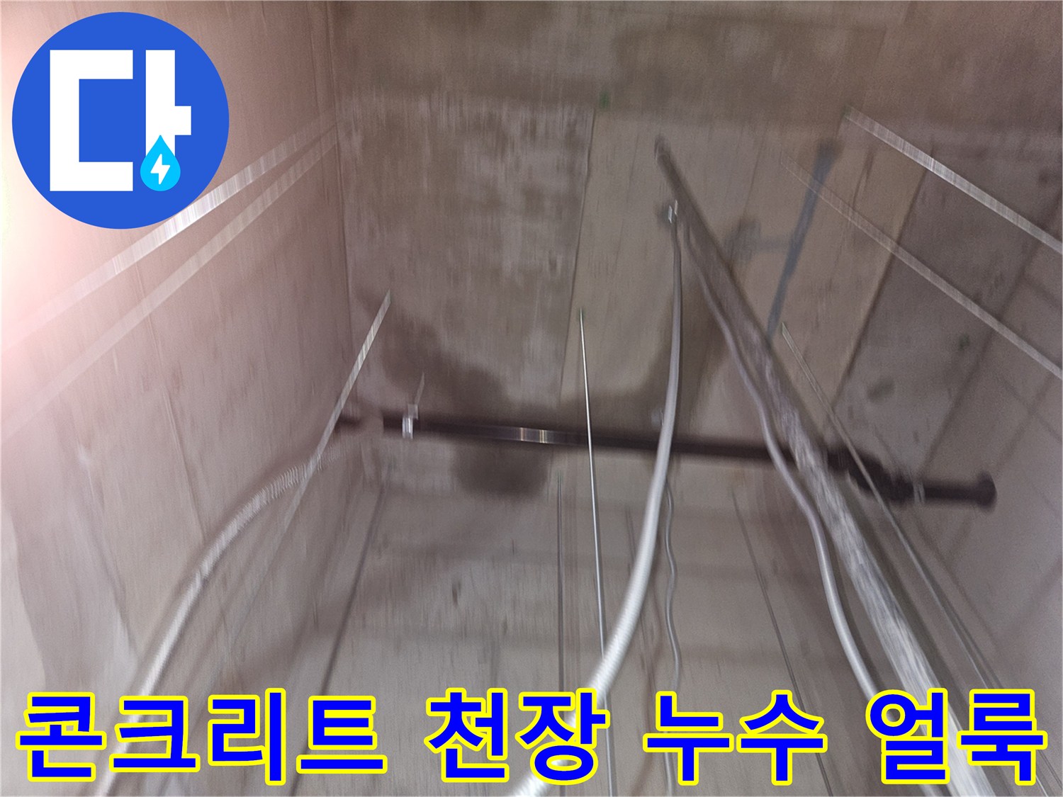 지하 창고 천장 콘크리트 벽면의 어두운 습기 흔적과 배관