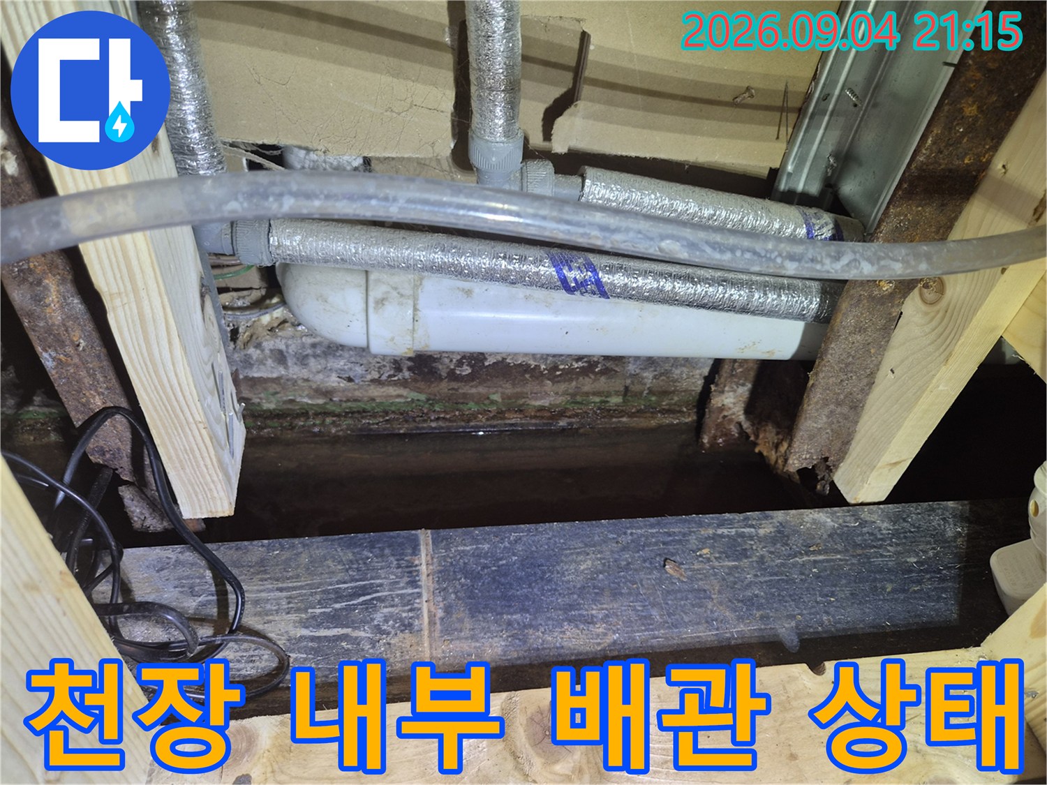 상가 천장 구조물 사이로 보이는 에어컨 배수 배관과 습기가 찬 부위입니다.