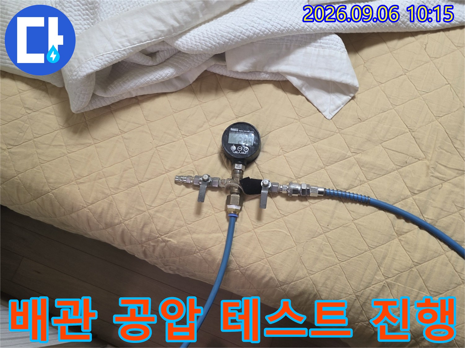파란색 호스와 압력계가 설치된 배관 점검 모습-누수 원인 분석