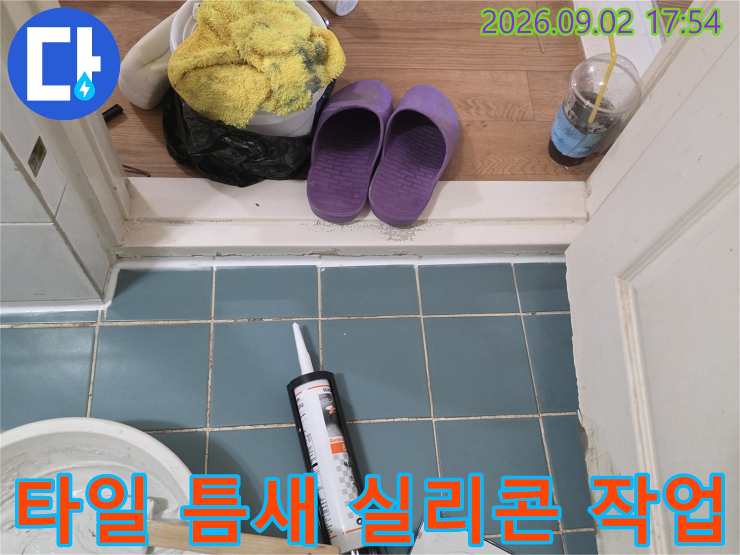 푸른색 타일 위 놓인 실란트와 작업용 용기