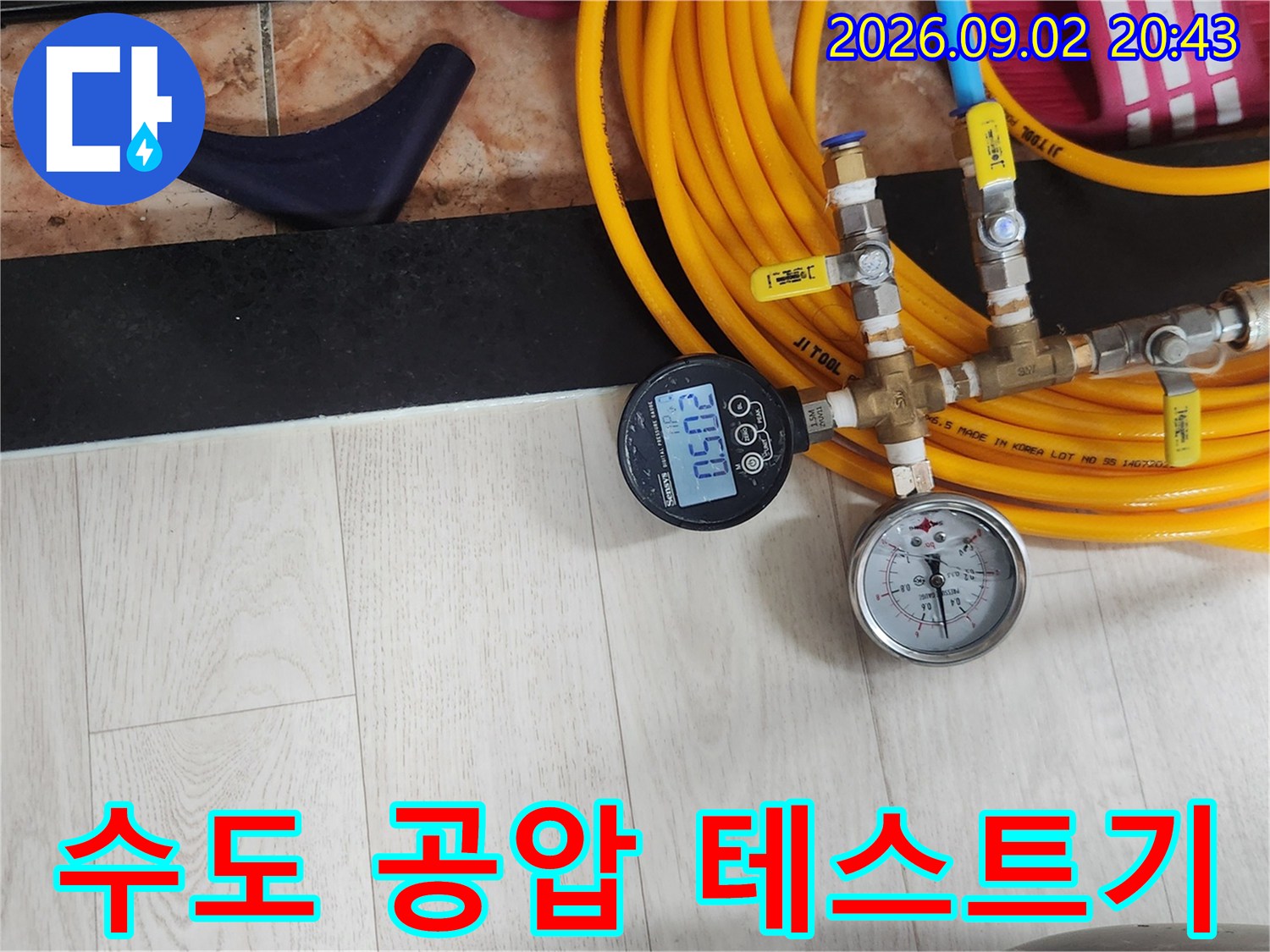 노란색 호스와 연결된-배관 압력을 측정하는-디지털 게이지