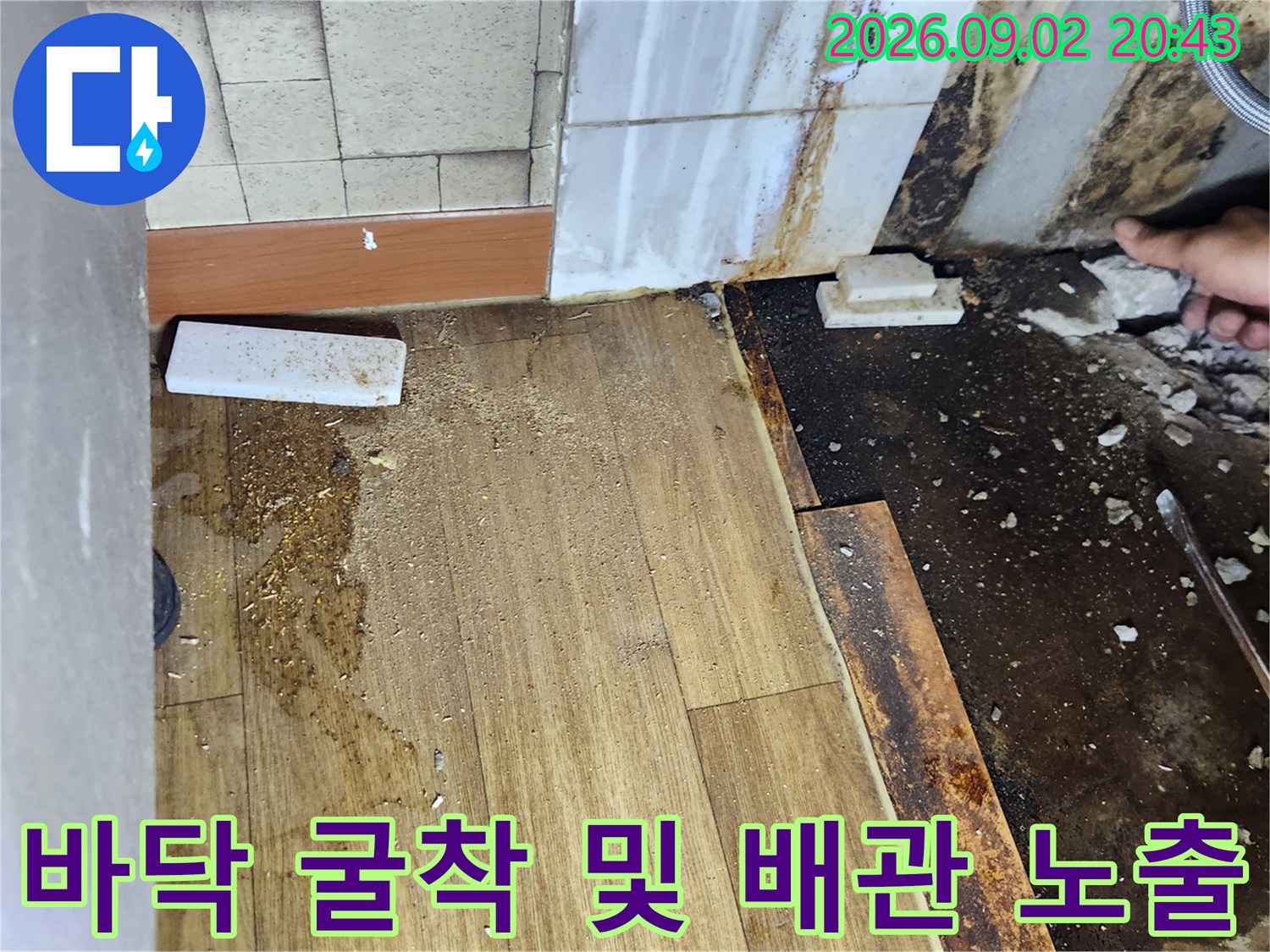 바닥재를 걷어내고 배관 확인을 위해 흙을 파낸 현장 사진입니다.