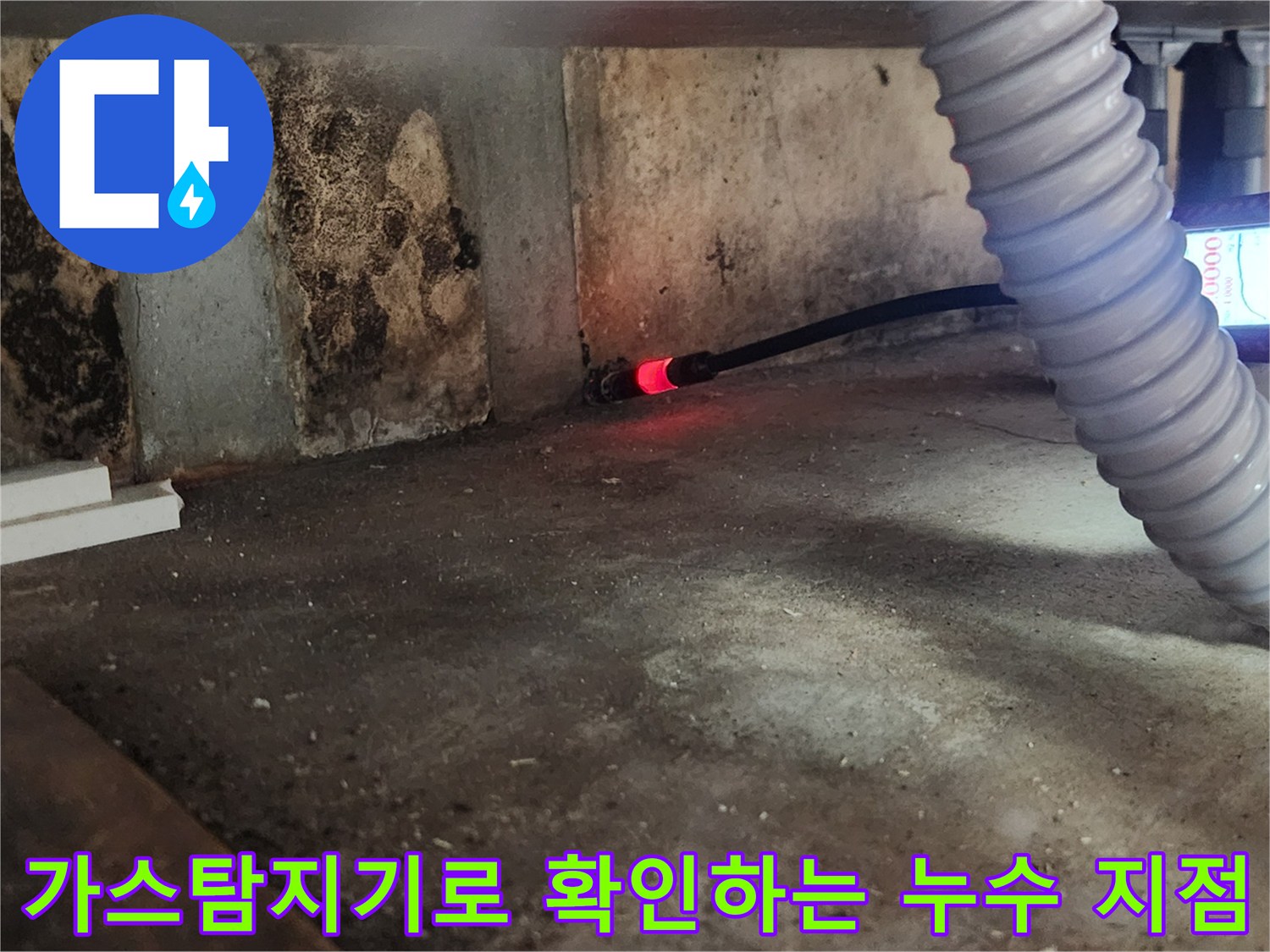 싱크대 아래 배관 부근에서 가스 탐지기를 사용하여 누수 위치를 추적하는 모습