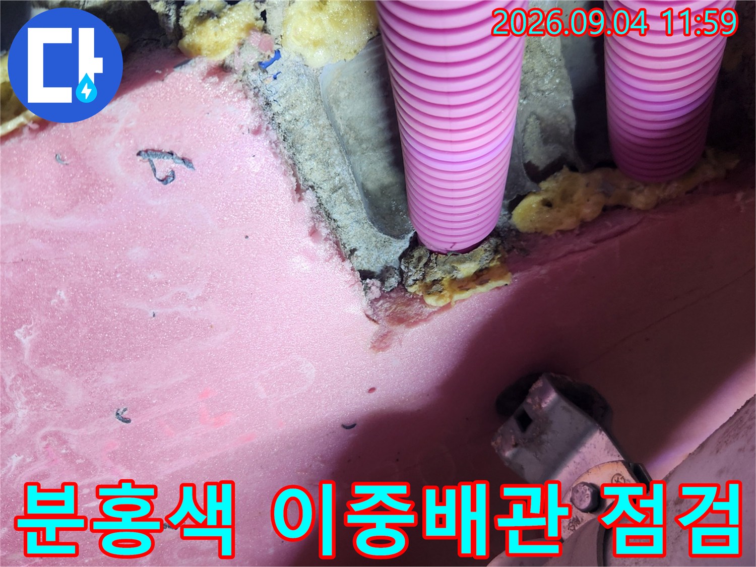 천장 내부 분홍색 이중배관과 주변 배관 자재의 상태를 촬영한 사진입니다.