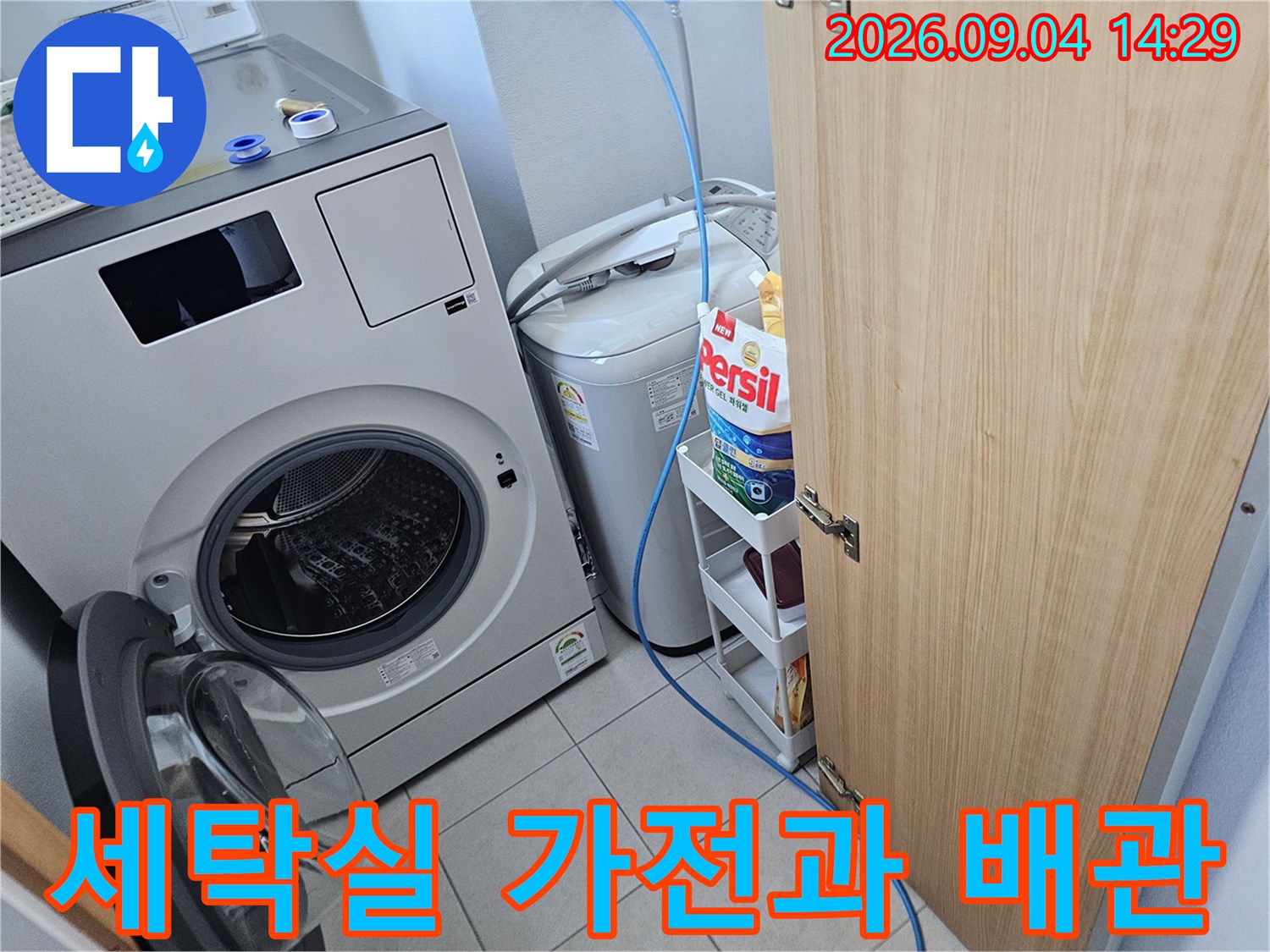 드럼 세탁기와 통돌이 세탁기가 나란히 배치된 세탁실 내부 전경입니다.