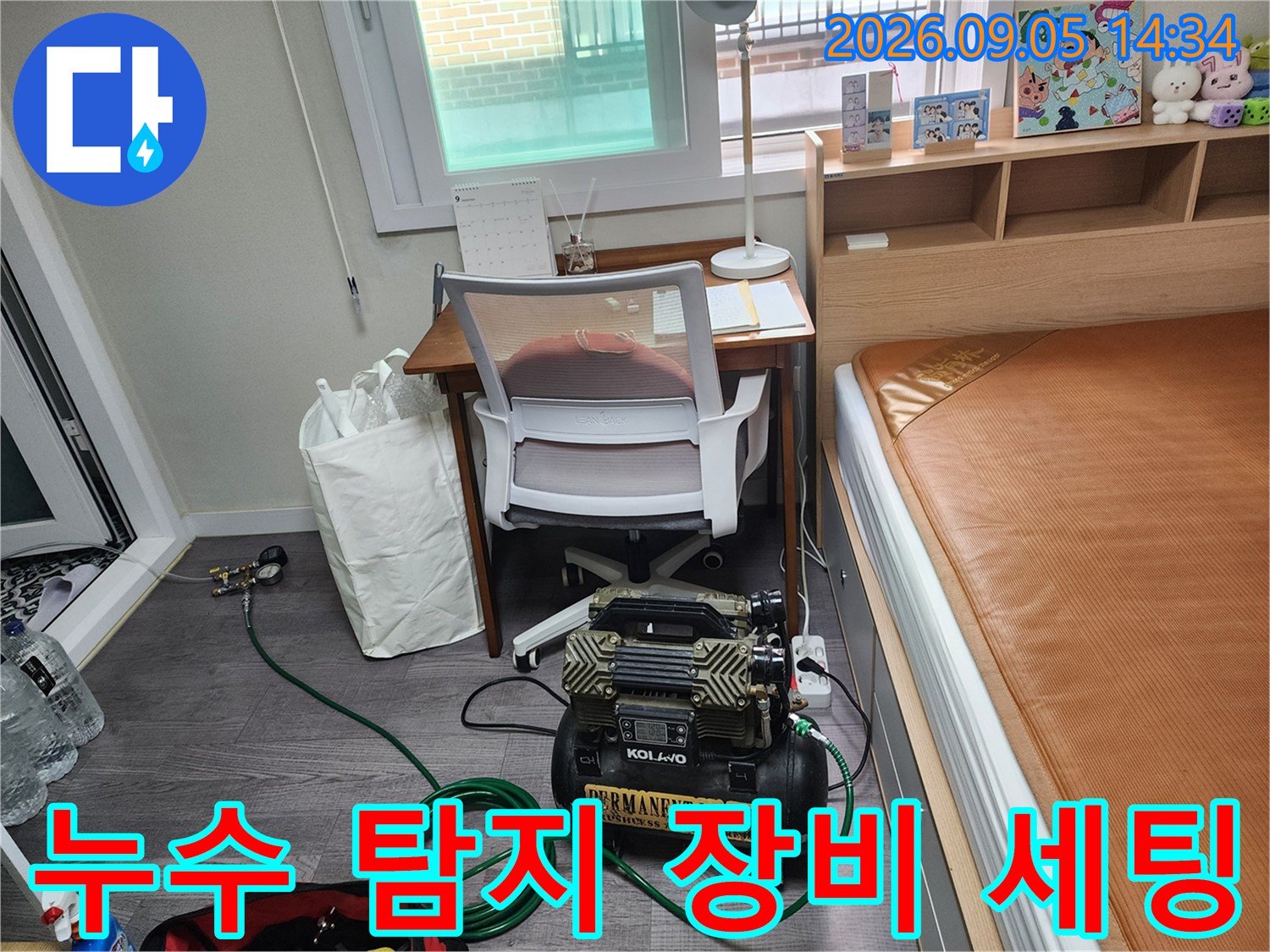 작업 공간에 배치된 누수 탐지용 컴프레셔와 압력 측정 호스입니다.