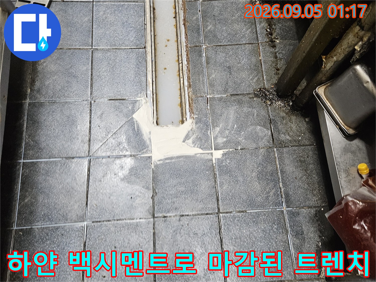 트렌치 배수구 주변에 백시멘트를 사용하여 틈새를 메운 모습