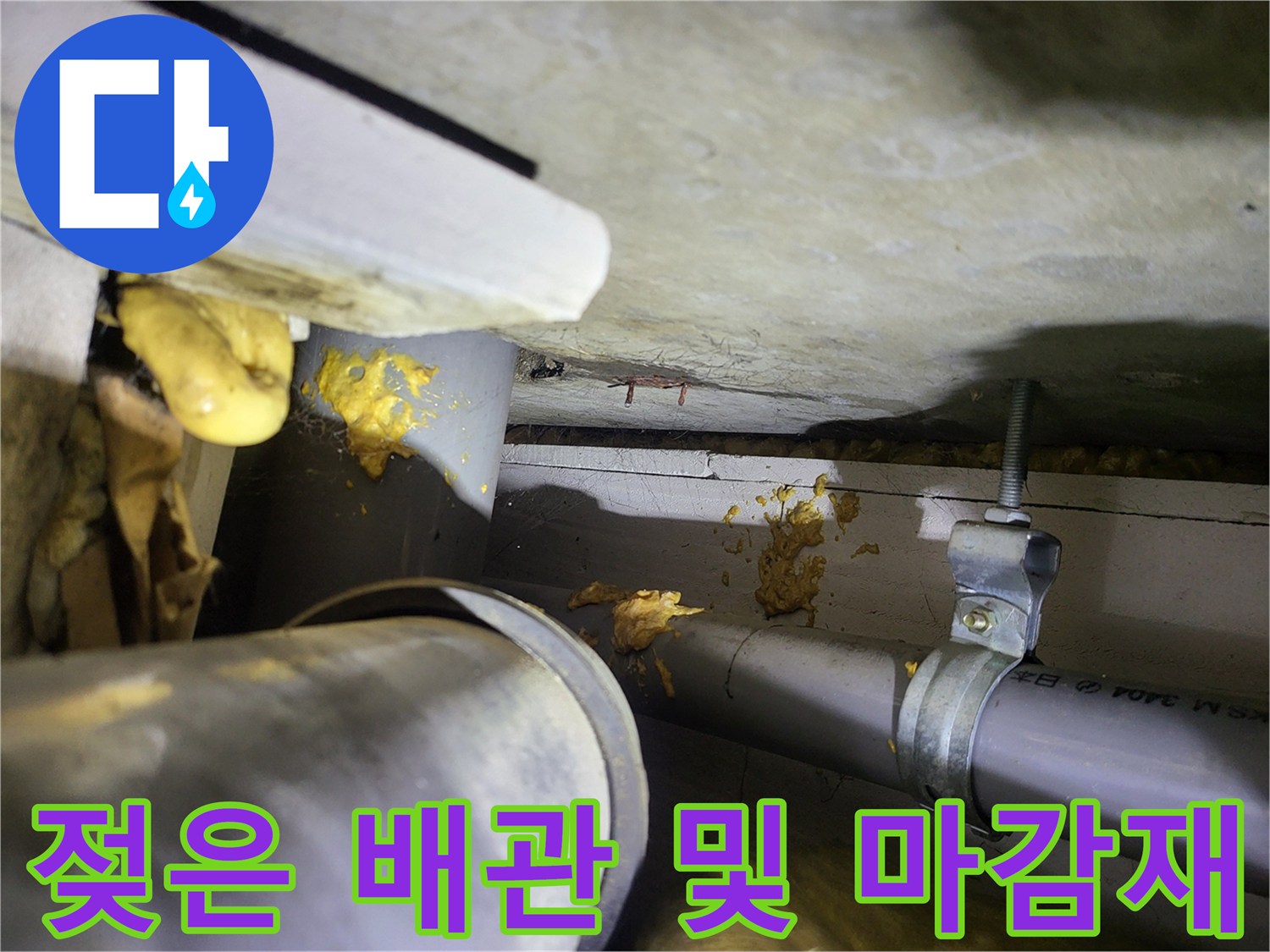 누수로 인해 노랗게 변색된 천장 구조물과 배관 연결부