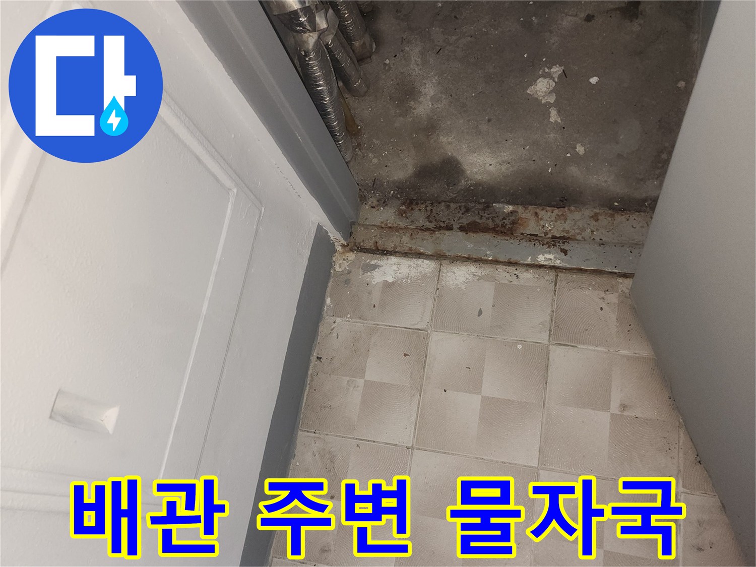 타일 아래쪽 벽면에 나타난 습기와 어두운 얼룩 부위