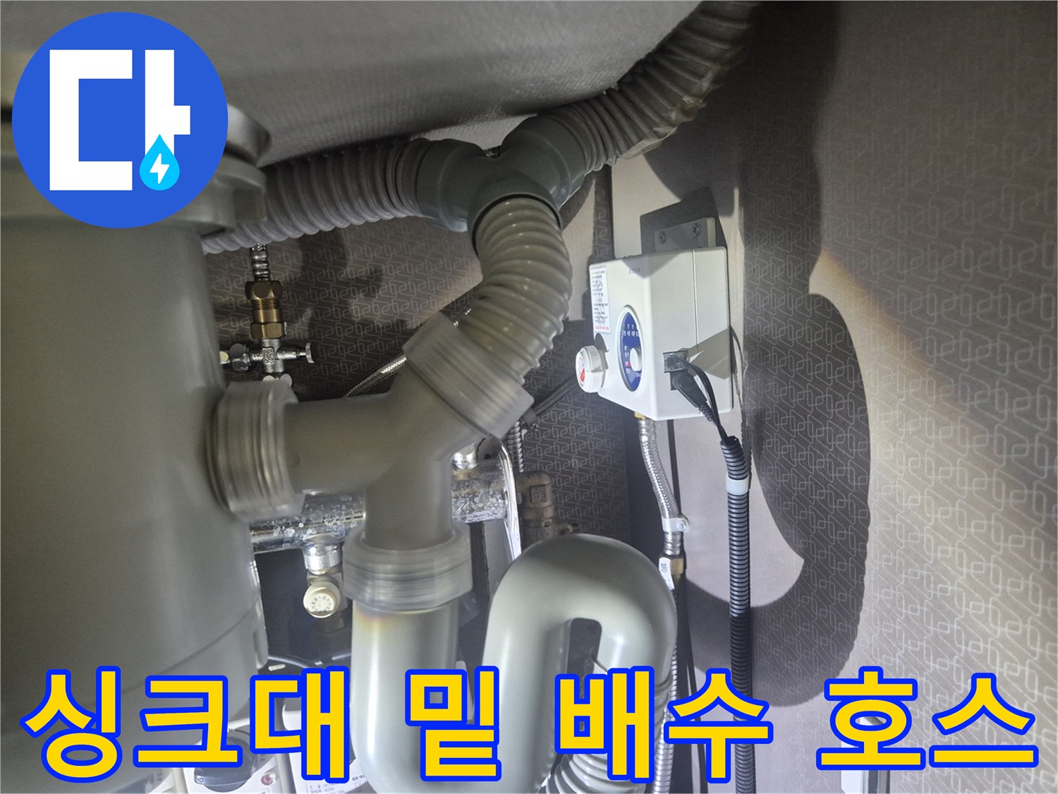 싱크대 하단에 설치된 회색 주름형 배수 관로
