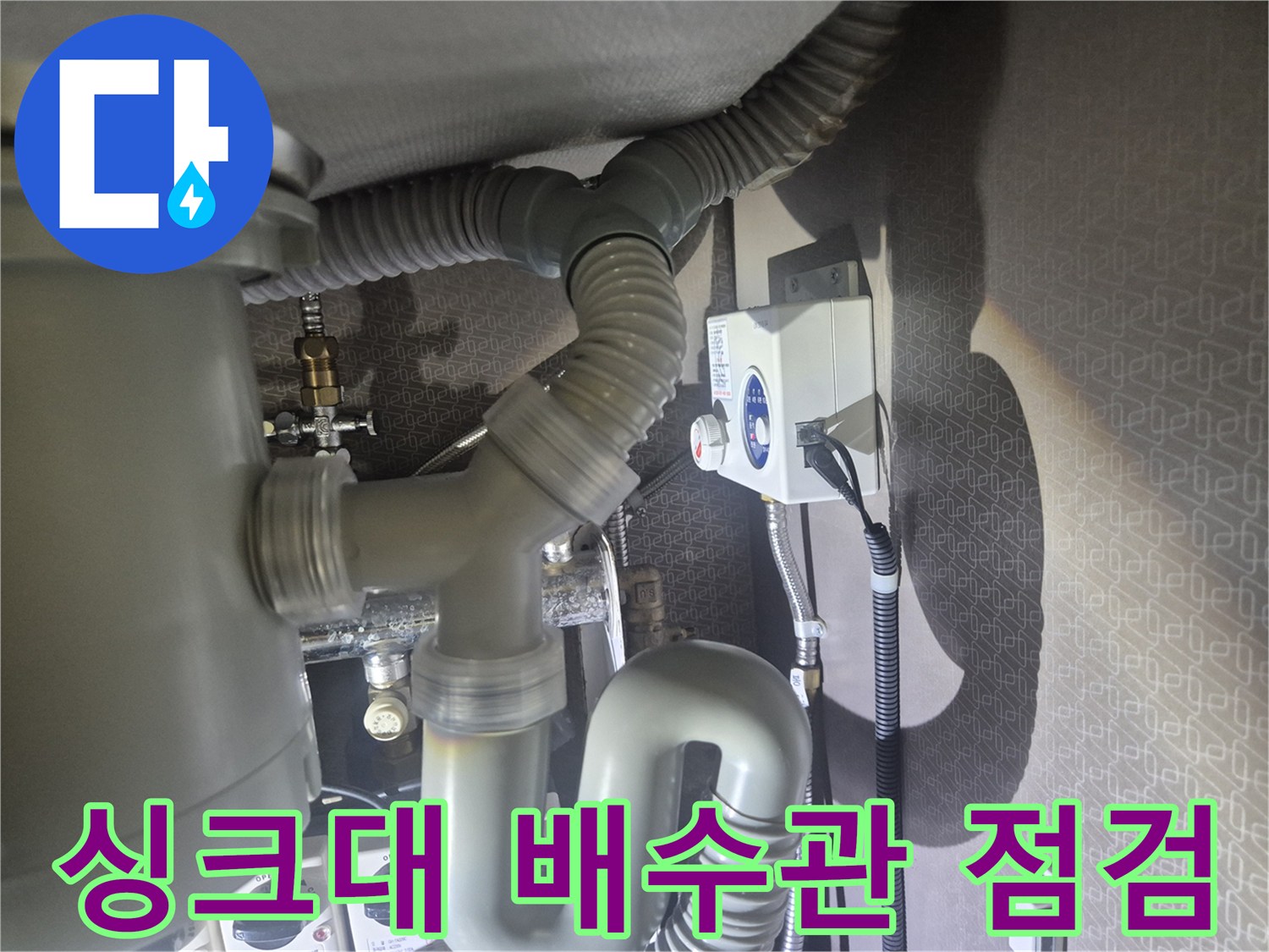 주방 싱크대 하부장 내부의 굴곡진 배수 호스와 연결 부위 모습