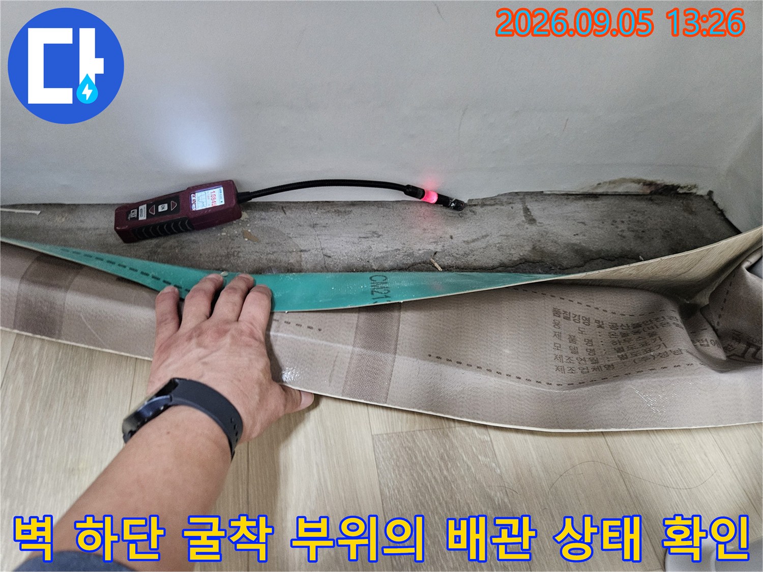 매립된 배관 주변을 굴착하여 가스 탐지기로 누수를 찾는 현장 사진입니다.