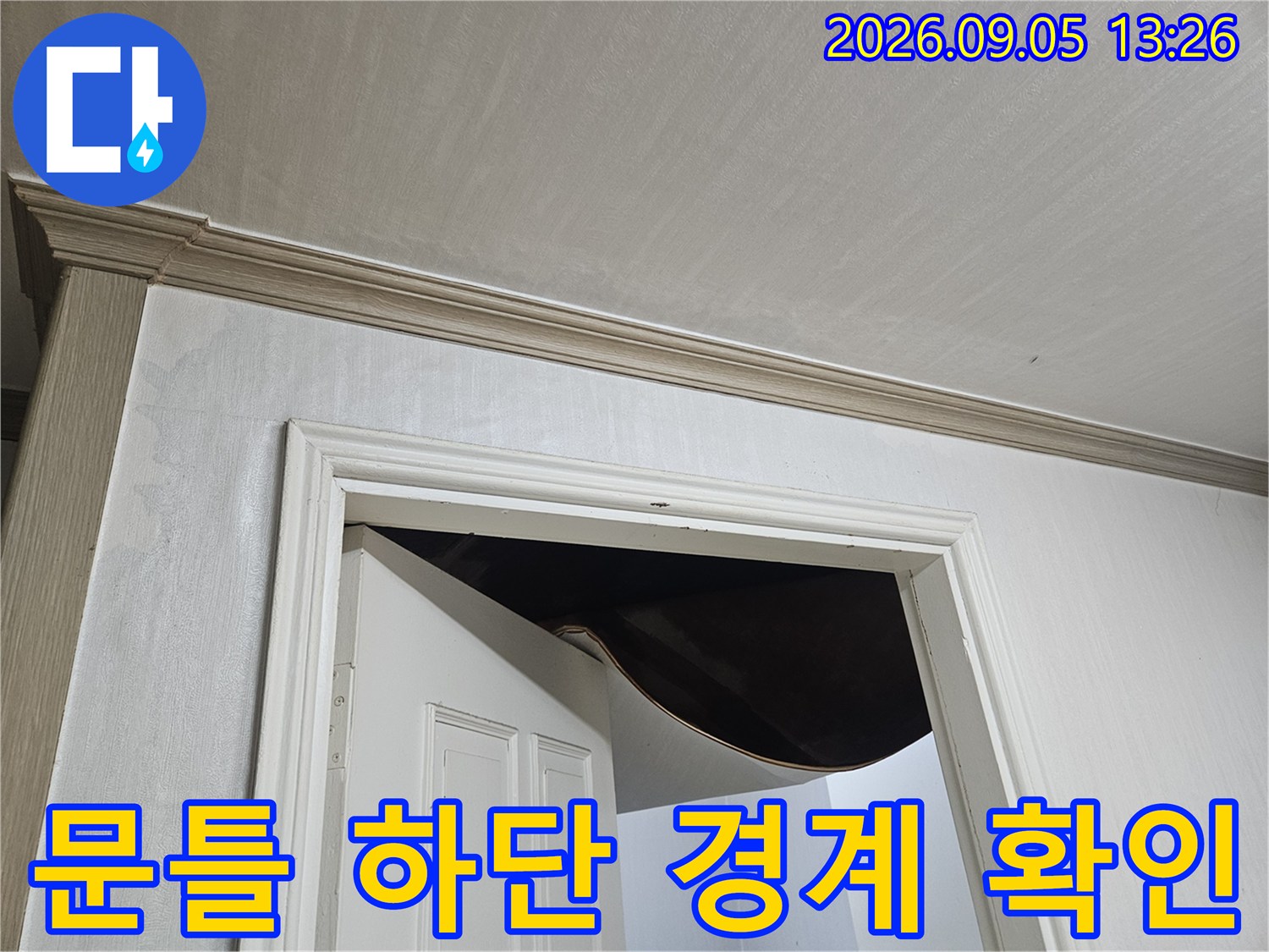하얀색 문틀 아래 벽면의 상태를 촬영한 모습-누수 탐지 현장