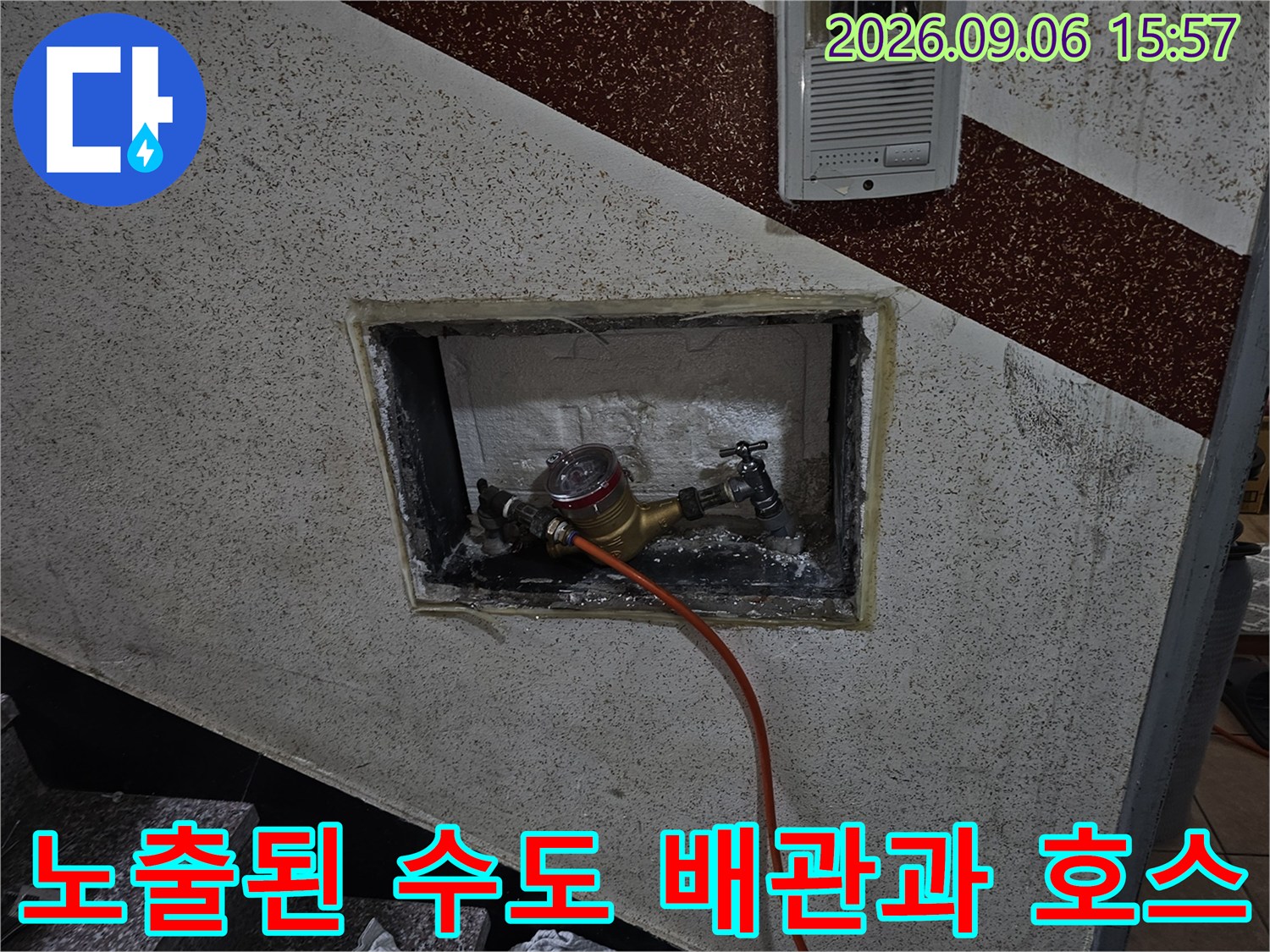 벽면 타공 구간 내부에 설치된 금속 배관 부속과 점검용 압력 호스