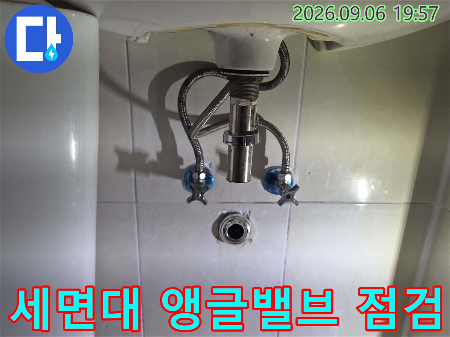 세면대 하부의 파란색 손잡이 밸브와 배관 연결 상태