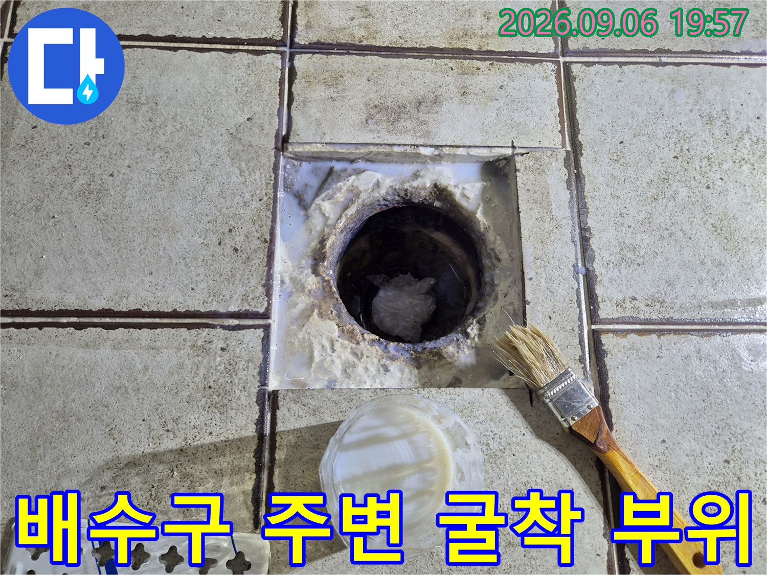 욕실 타일 아래-배수관 입구와 노출된 내부 구조물