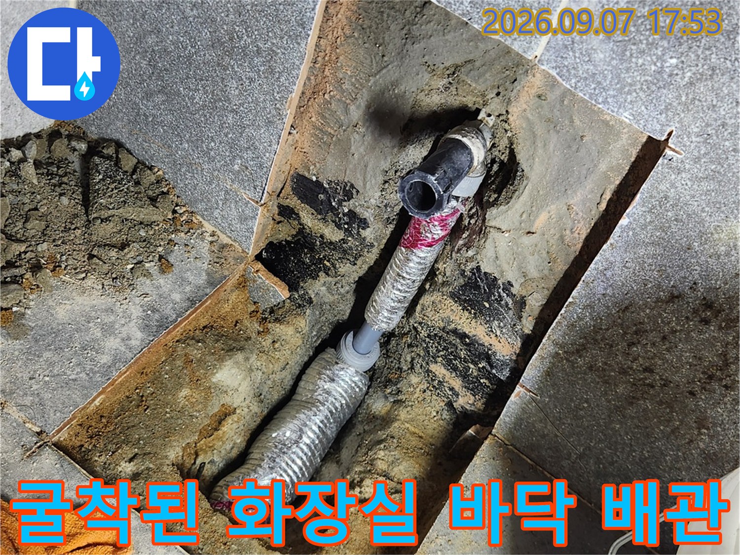 타일 아래 드러난 수도 배관과 보온재로 감싸진 수선 부위