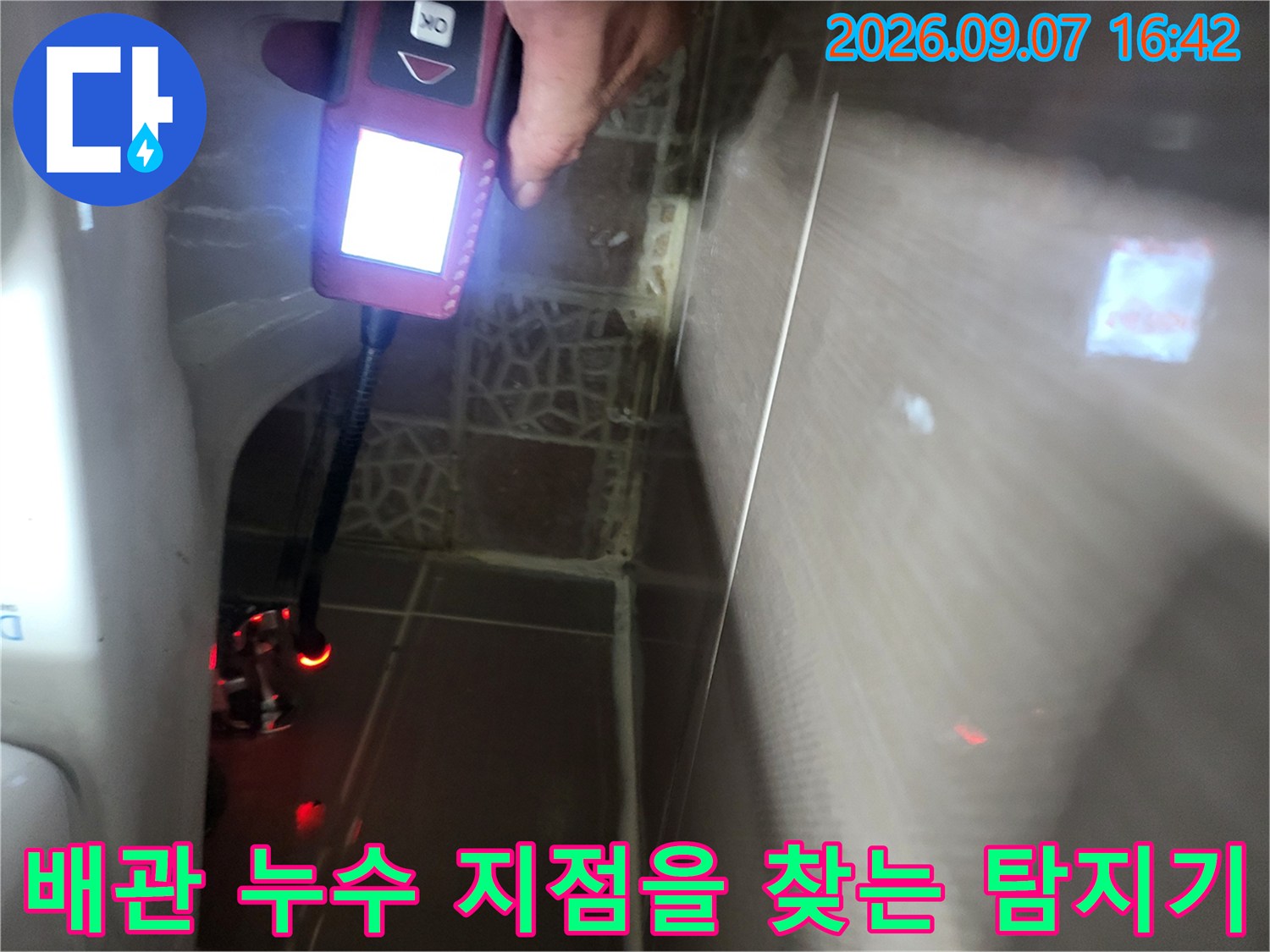 변기 주변 타일 벽면을 향해 가스식 탐지기를 조작하고 있는 모습입니다.