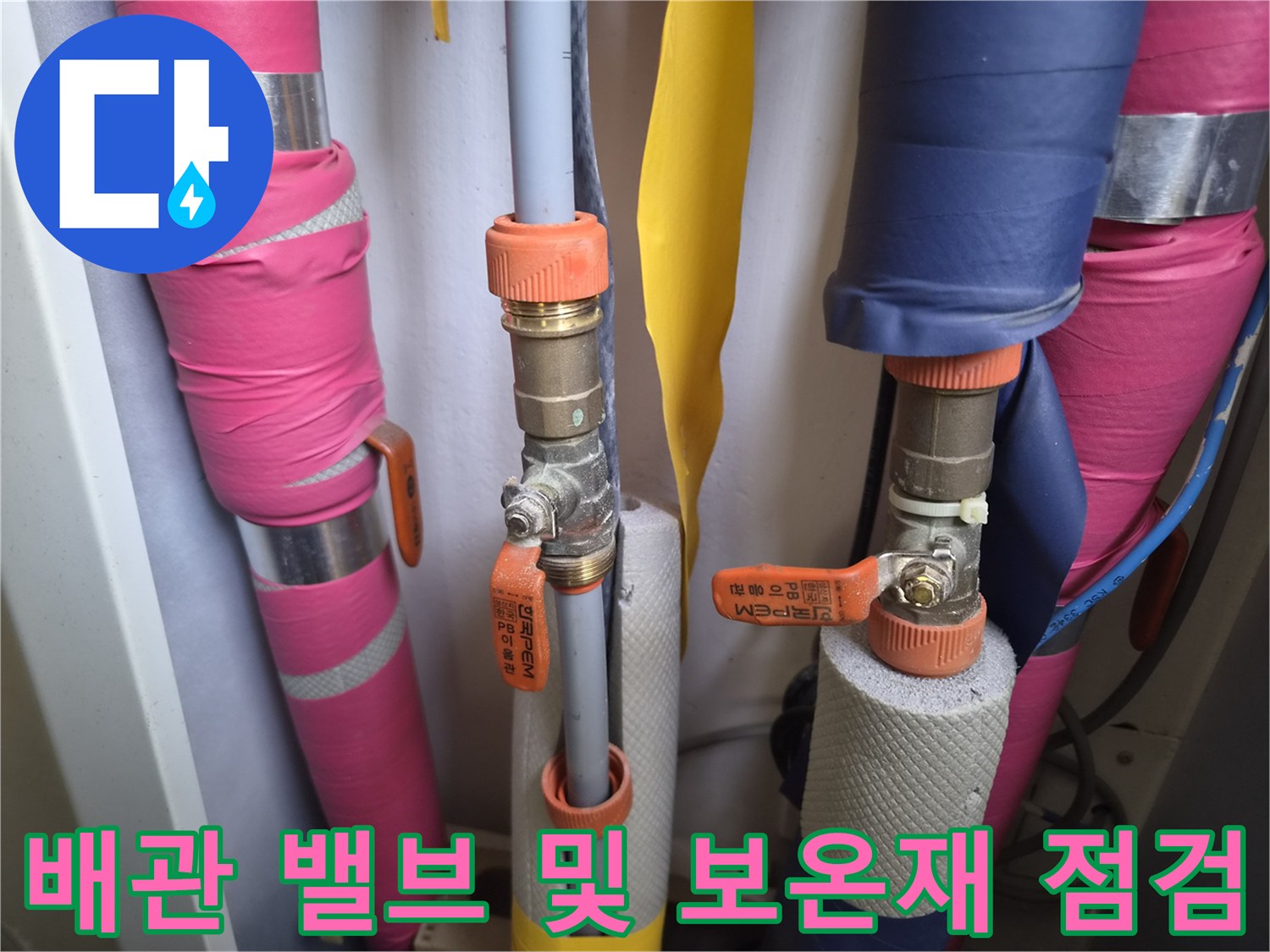 배관 연결 부속과 주황색 레버 밸브의 근접 촬영