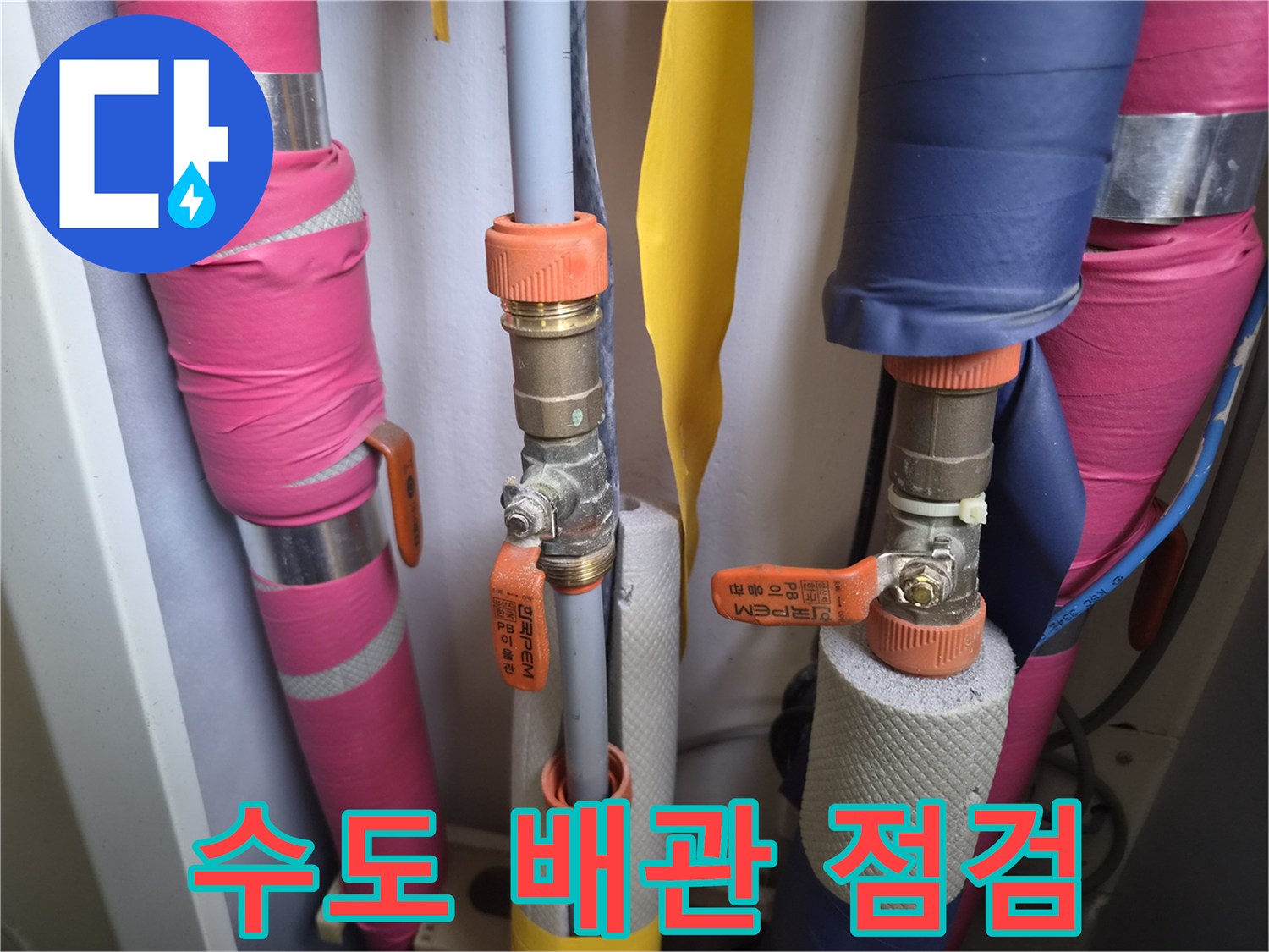 보온재가 감긴 배관과 주황색 손잡이의 밸브 부위 사진입니다.