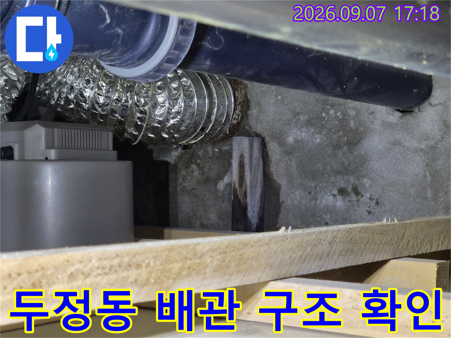 천안 두정동-검은색 관과 은색 호스가 설치된 배관 하부 모습