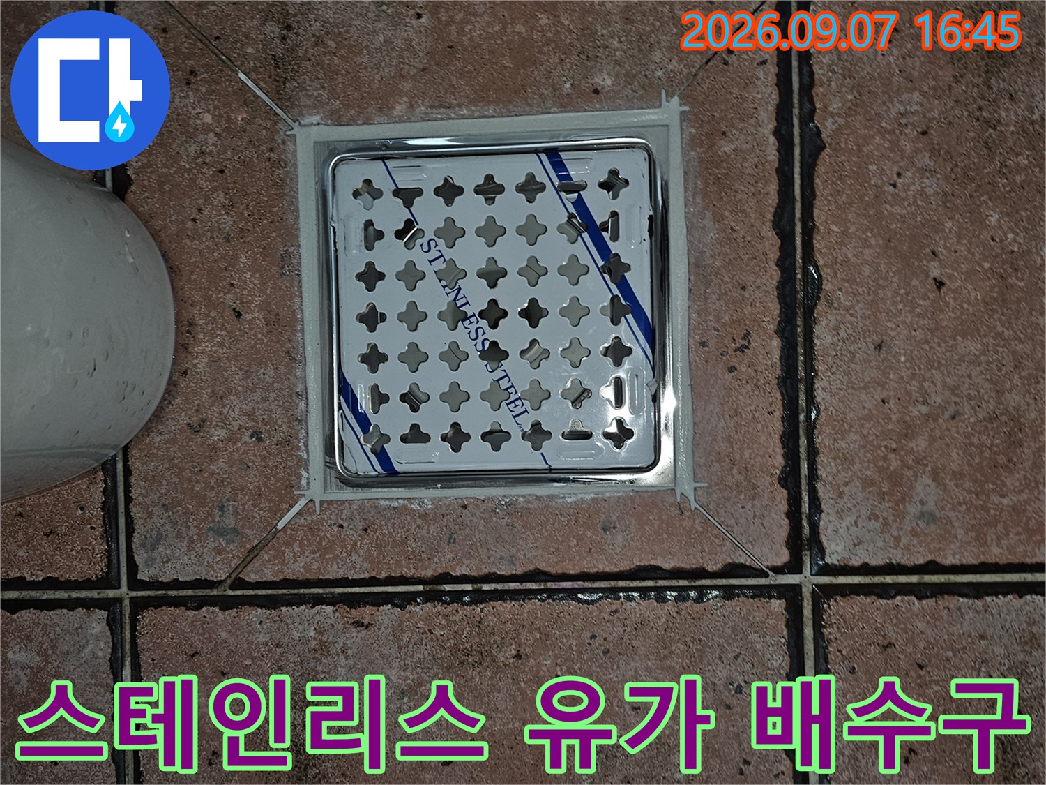 사각 모양의 스테인리스 배수구 덮개와 주변 타일 모습입니다.