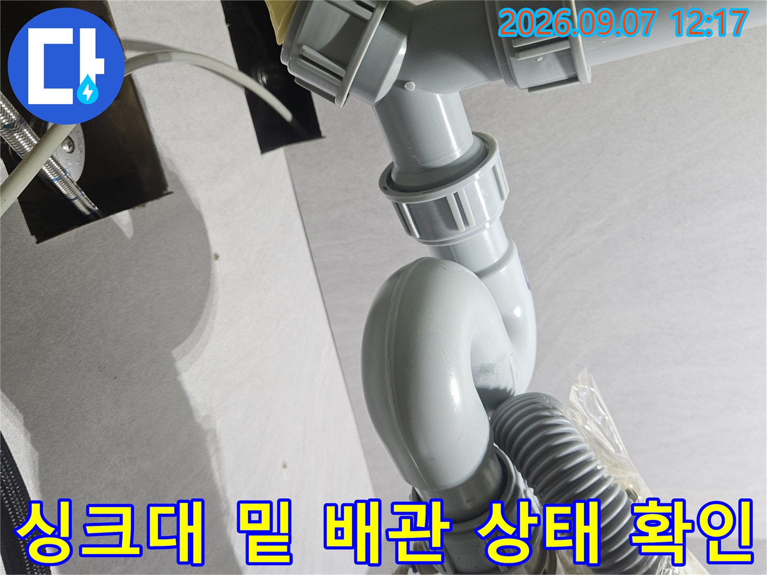 싱크대-하부의 훼손된 호스와 연결된 배수 트랩 상세 사진