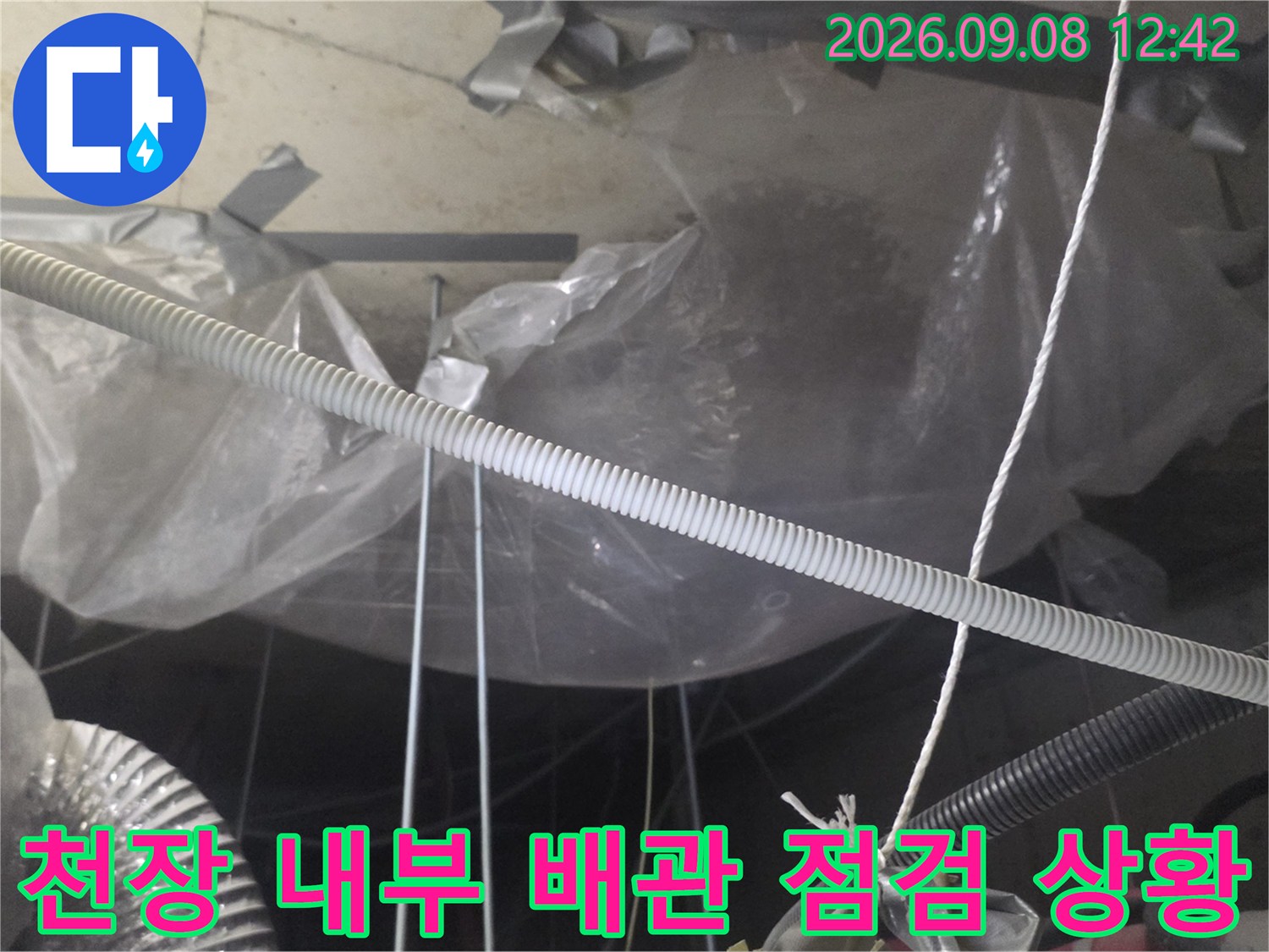 비닐 보양이 된 천장 내부의 배관과 연결 부위를 촬영한 사진입니다.