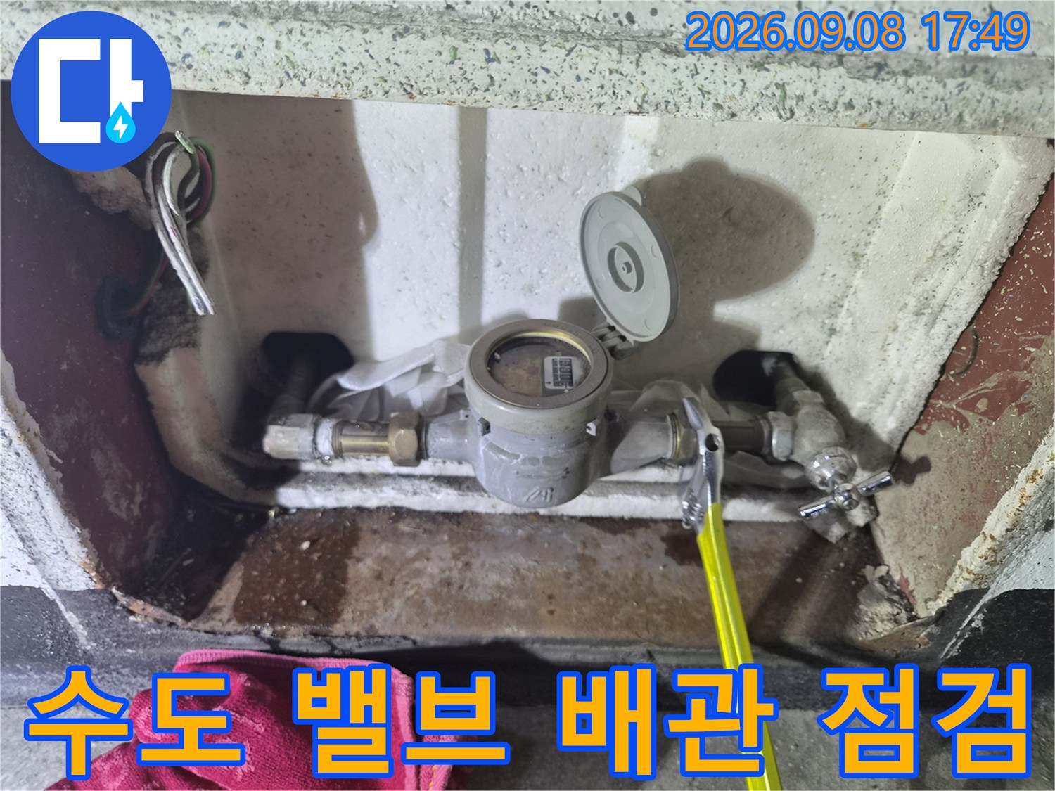 수도 계량기와 연결된 밸브 및 금속 부속의 근접 촬영본입니다.