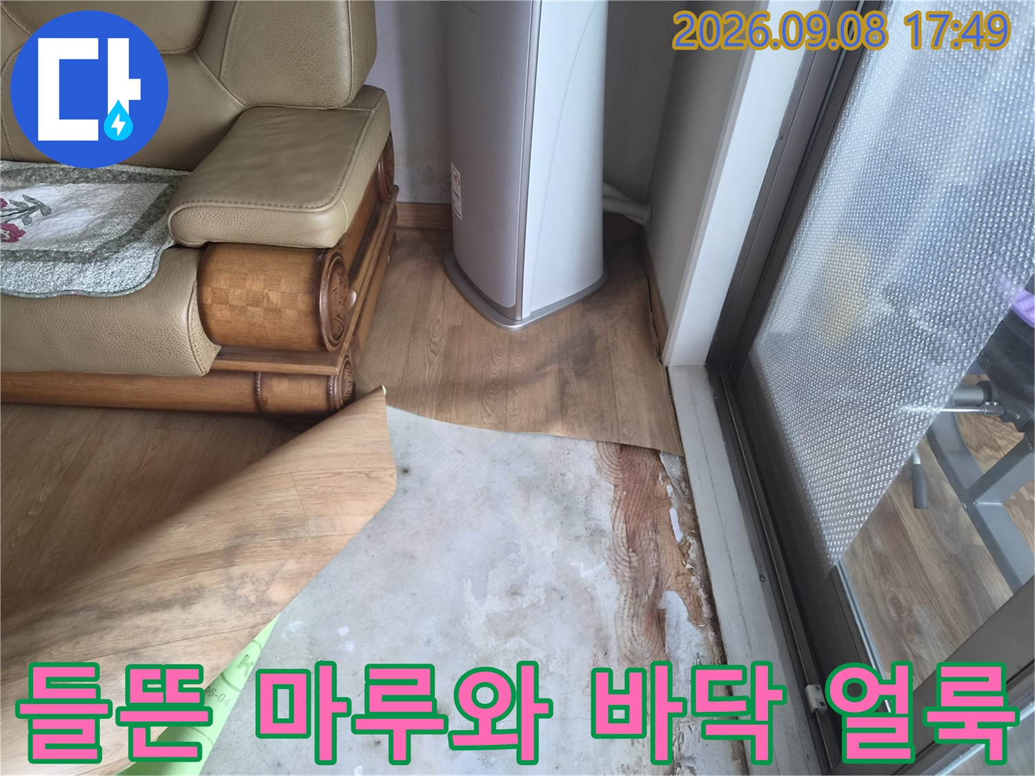 습기로 인해 틈이 벌어지고 변색된 마루 자재 사진입니다.