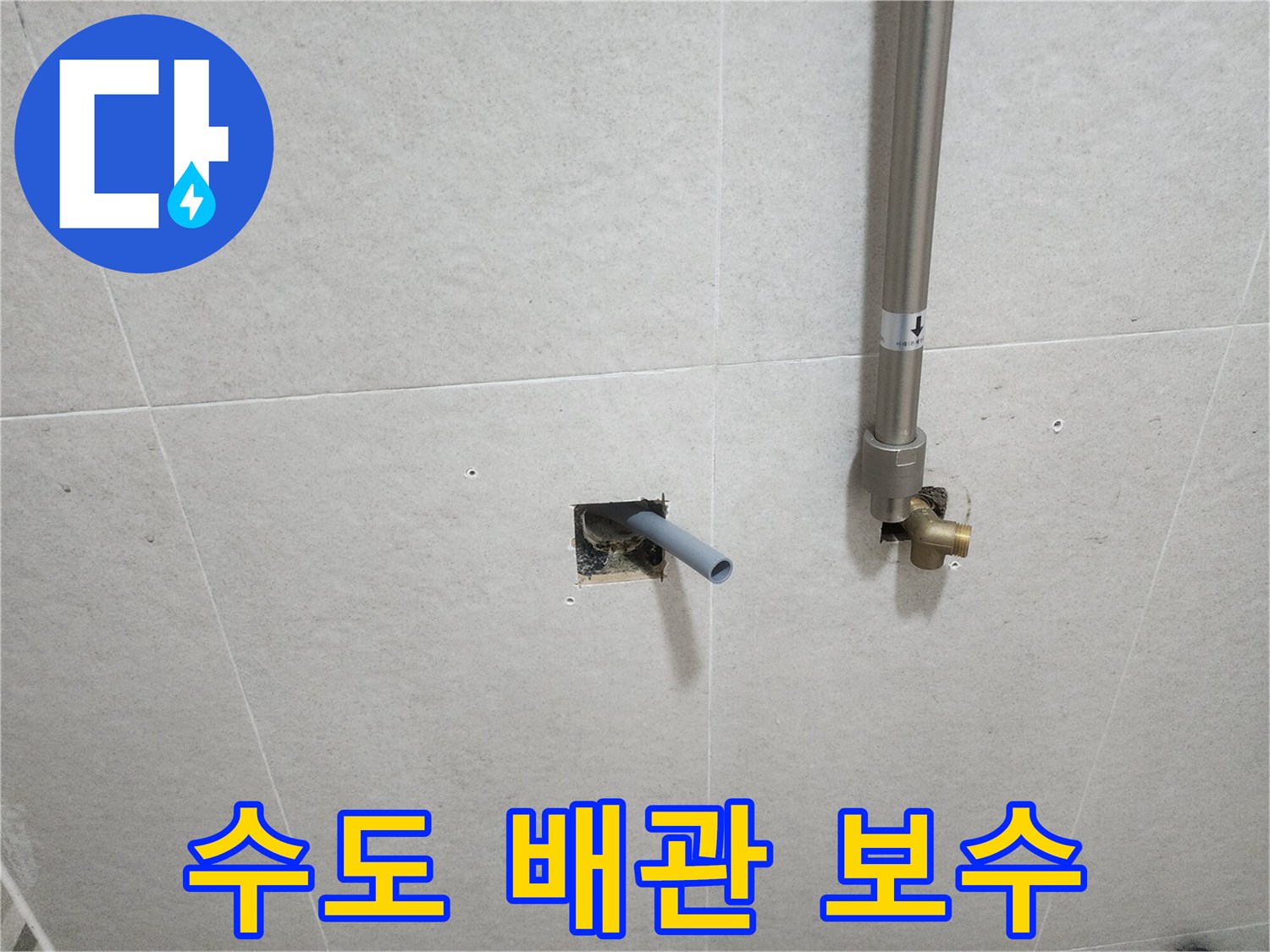 타일 틈새로 노출된 은색 배관과 연결 부속