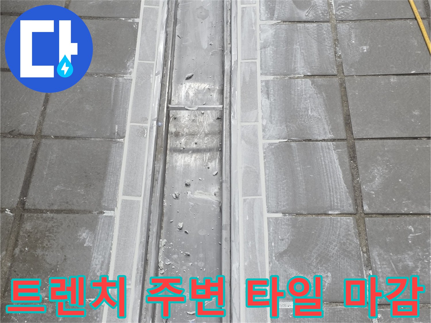 스테인리스 트렌치-주변 타일과 배수구 연결 부위 근접 촬영