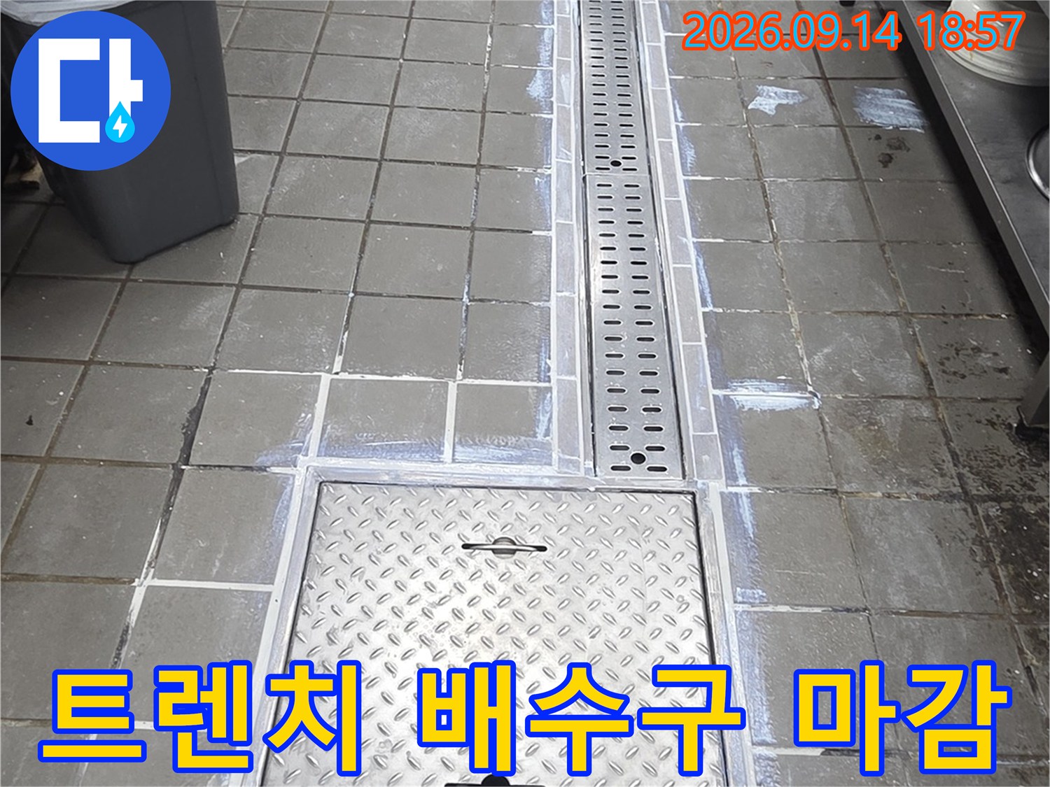타일 바닥과 연결된 스테인리스 트렌치와 다이아몬드 패턴 점검구 상세 사진