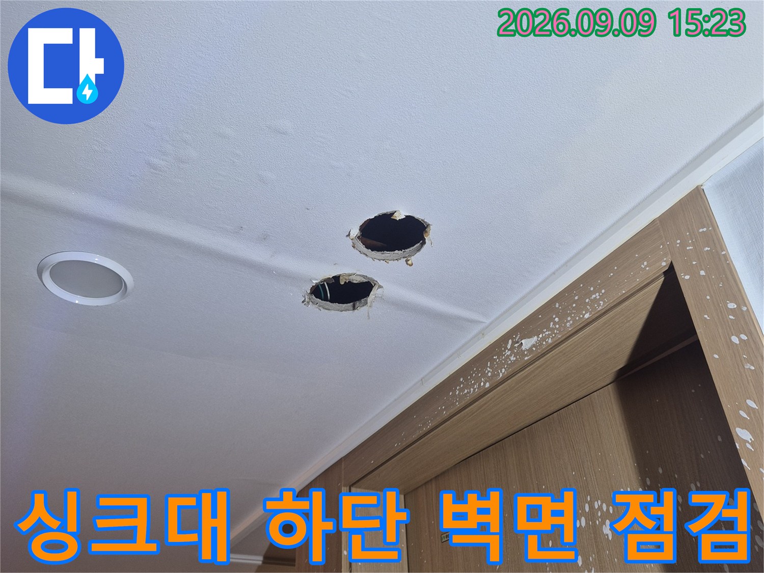 싱크대 하부장 아래 벽면에 위치한 배관 구멍과 주변 오염 상태를 보여줍니다.