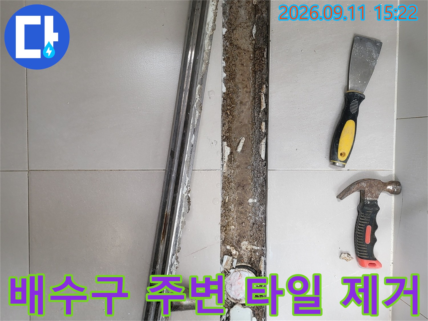 중곡동 화장실 배수구의 금속 덮개와 주변 타일을 제거하여 내부를 노출시킨 모습입니다.
