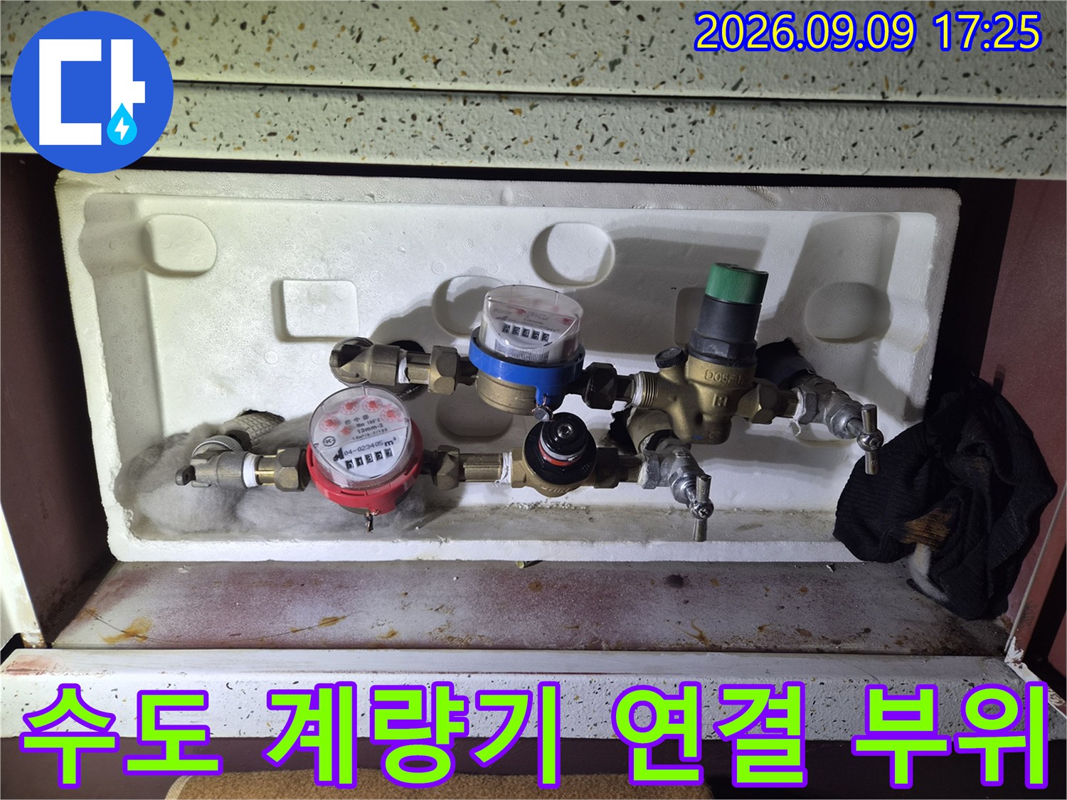 수도 계량기와 밸브가 설치된 계량기함 내부의 상세한 모습입니다.