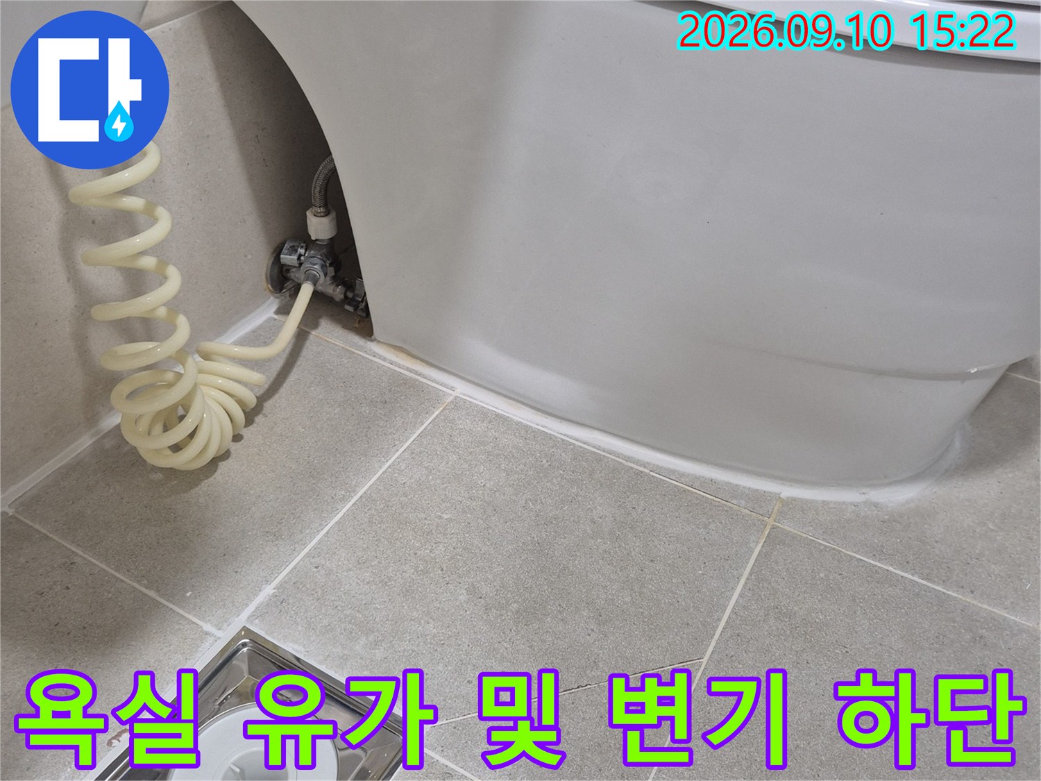 변기 옆 배수구-유가 주변 타일 마감과 배관 상태를 보여줍니다.